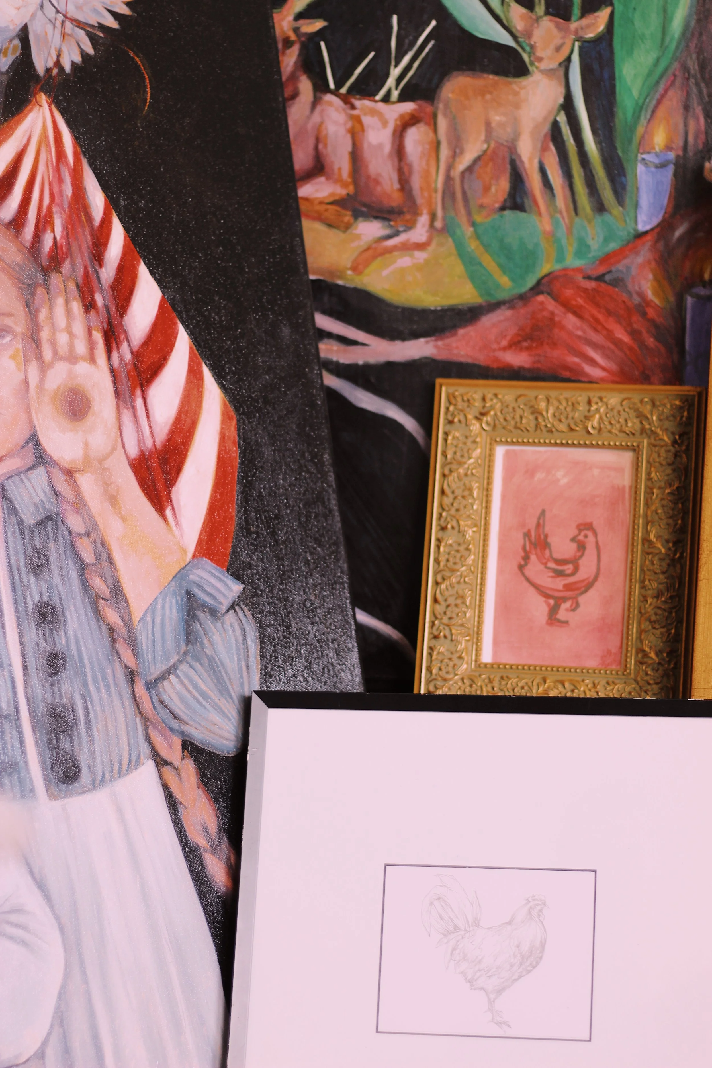 A framed sketch of a chicken on display at an art exhibit, with part of a colorful painting of animals and a human figure visible in the background.