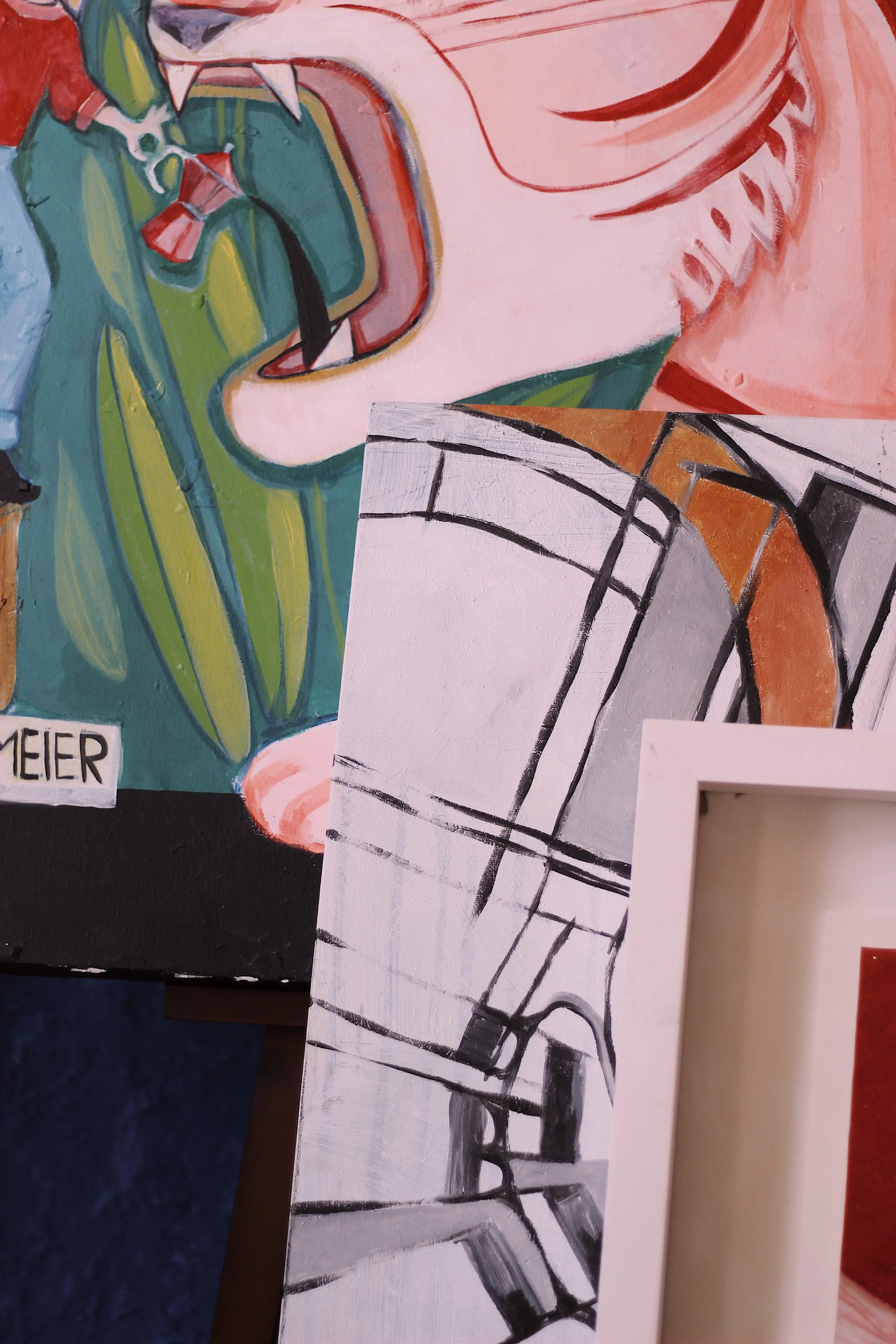 Close-up view of a colorful abstract painting with a partly visible black and white sketch overlay. The painting features shapes and colors including green, red, peach, black, and white.