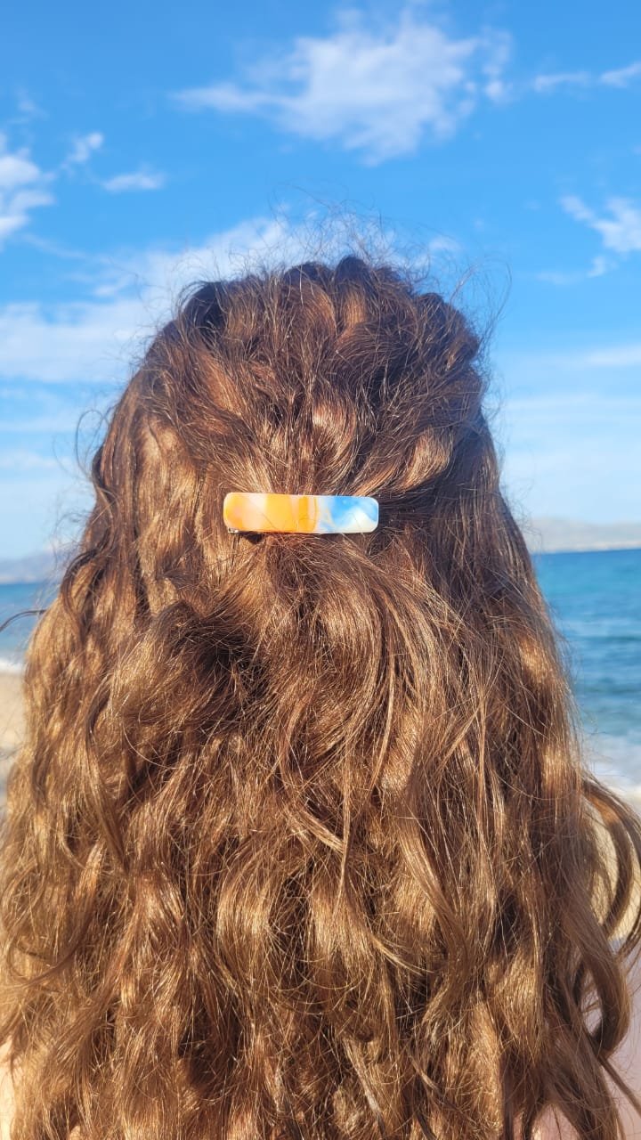 cabello rizado con una especie de pinza de cabello de colores en la parte superior