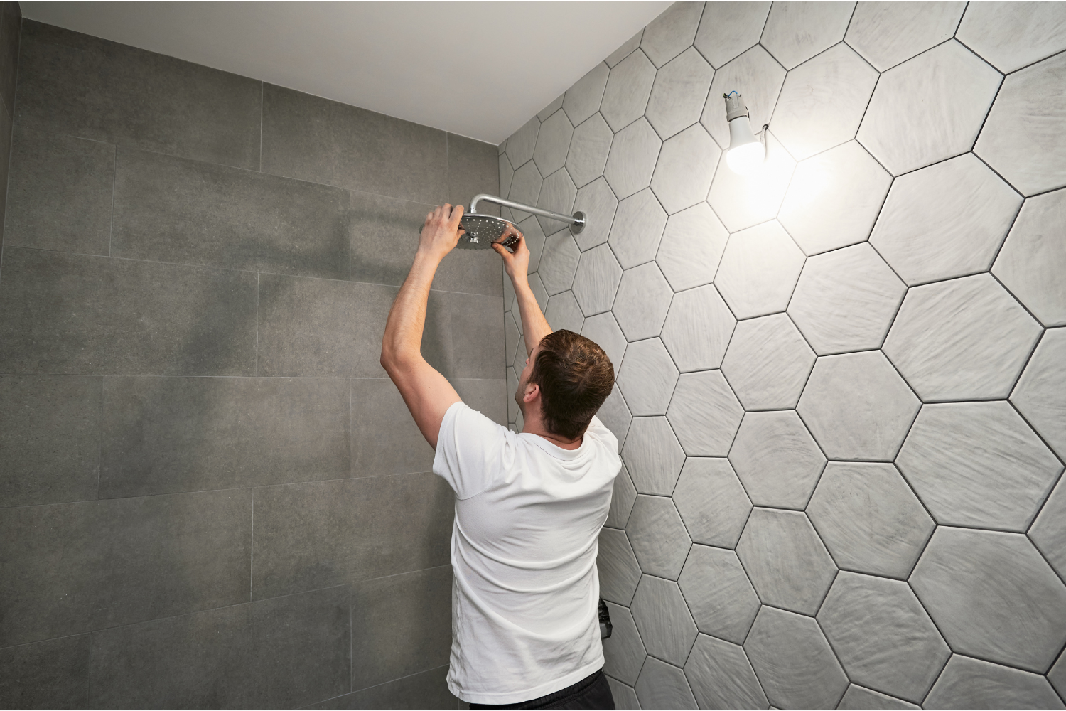 image of a man installing a shower fixture.