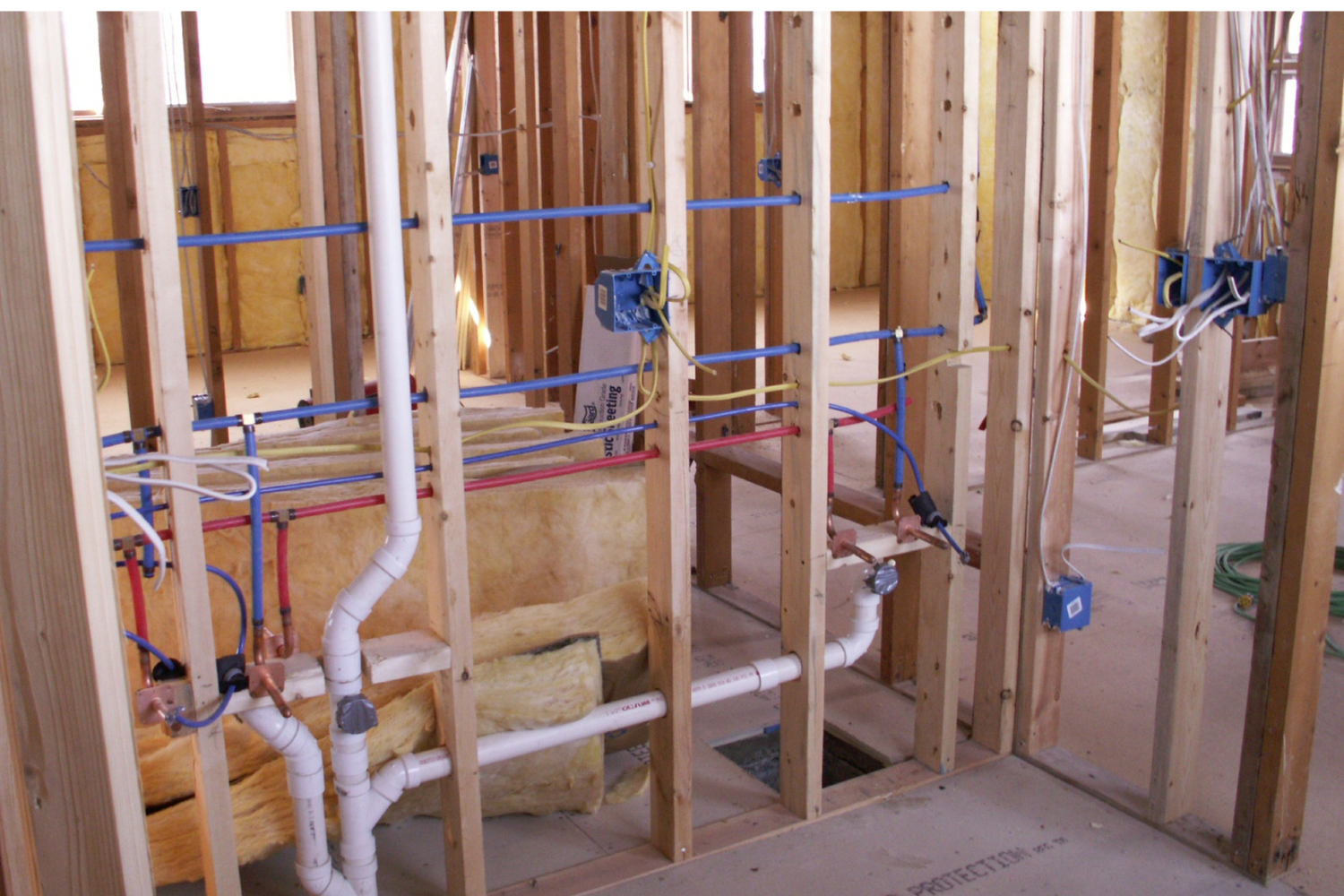image of a new build house with new plumbing in the walls, before the drywall stage.