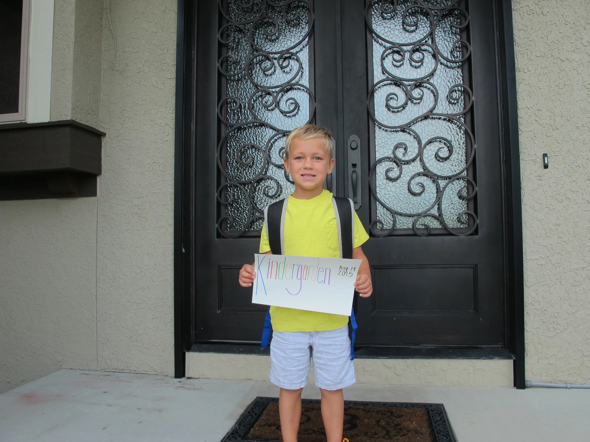 Young boy holding a sign for kindergarten