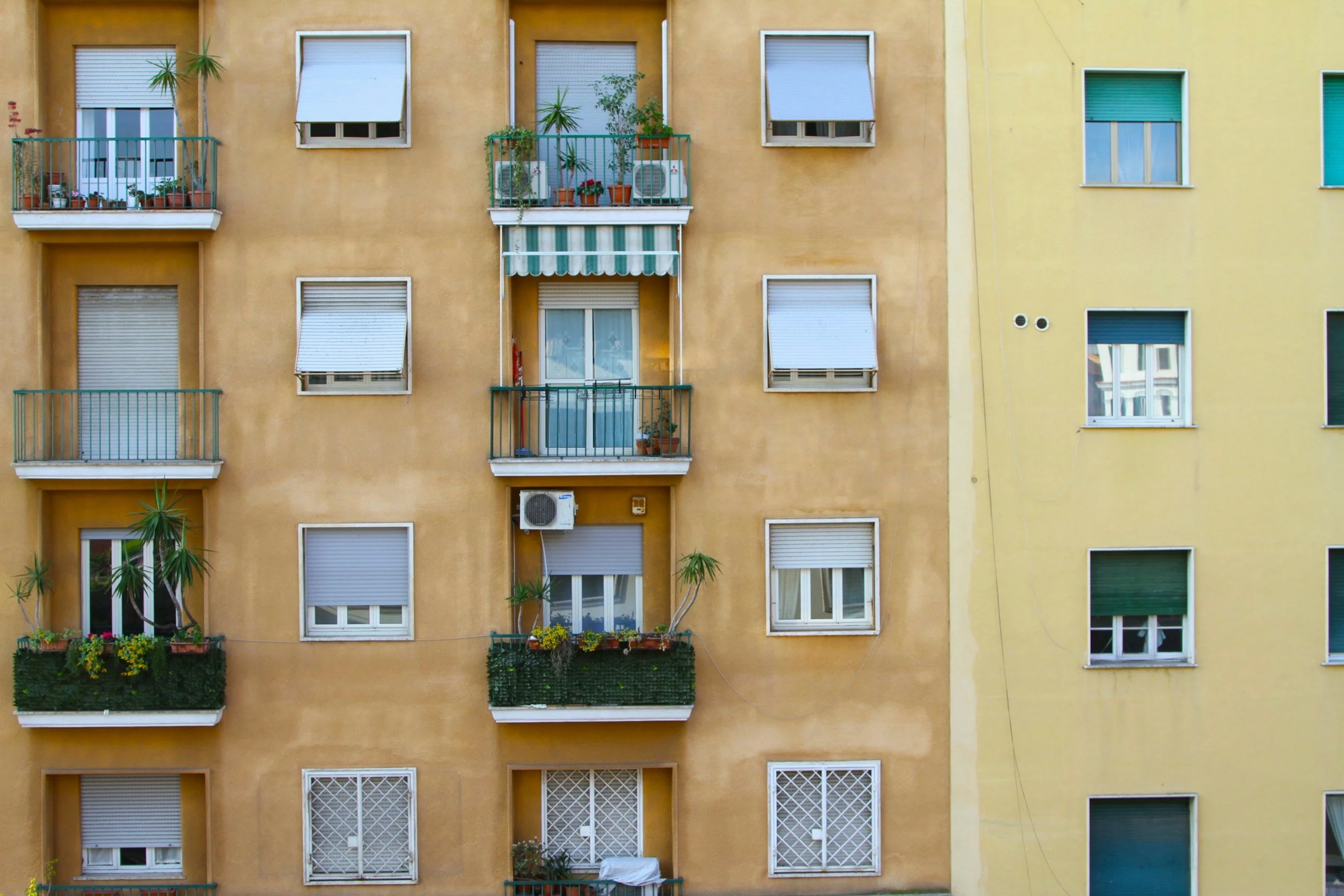 Mehrstöckiges Apartmentgebäude mit Fenstern, Balkonen und Pflanzen