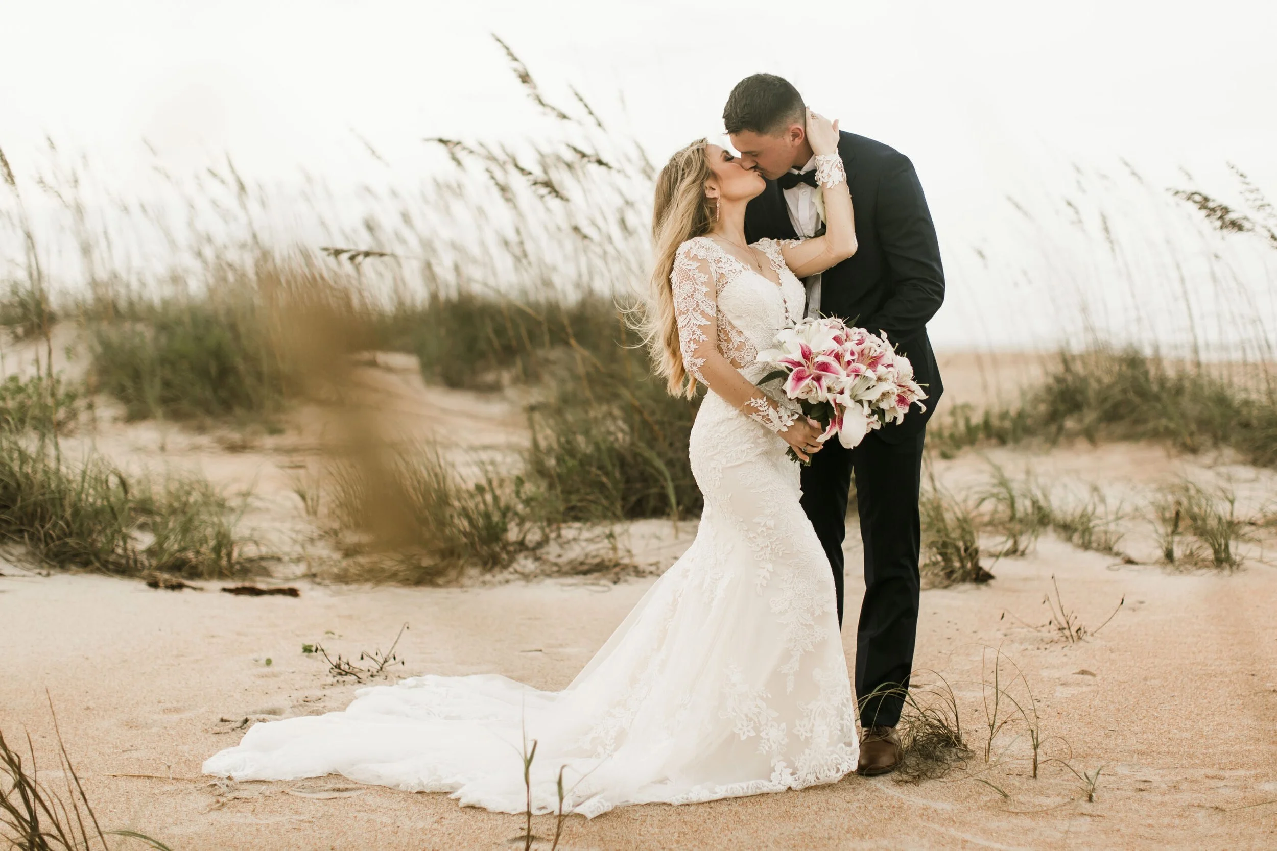 Bride and groom walking down the aisle at a beach wedding, holding hands and smiling, with guests watching and clapping at Vacía Talega.