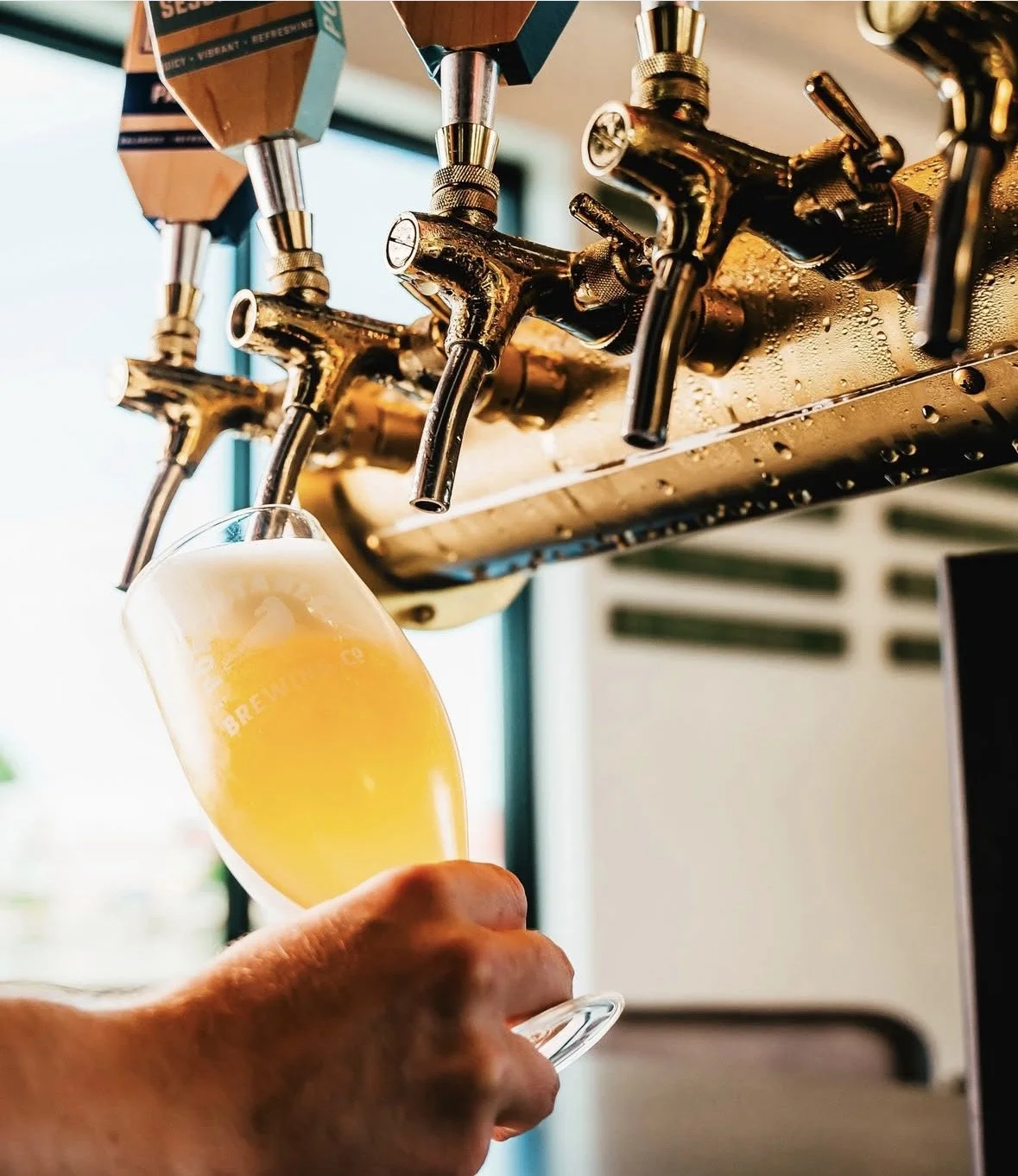 Pouring a glass of beer from a tap at a brewery or bar.