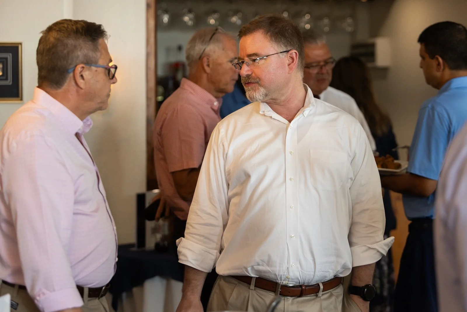 Group of people having conversations at a social gathering or event