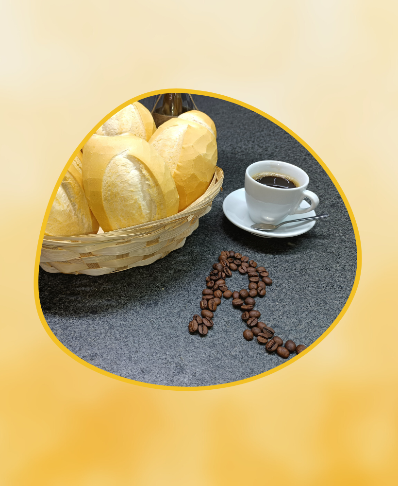 Pão francês na cesta, xícara de café preto com colher, e grãos de café formando uma seta para cima sobre uma mesa escura
