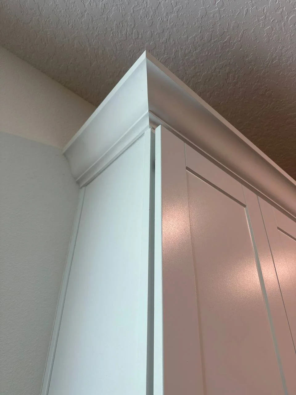 Custom crown molding installation above white cabinetry in Orlando kitchen.