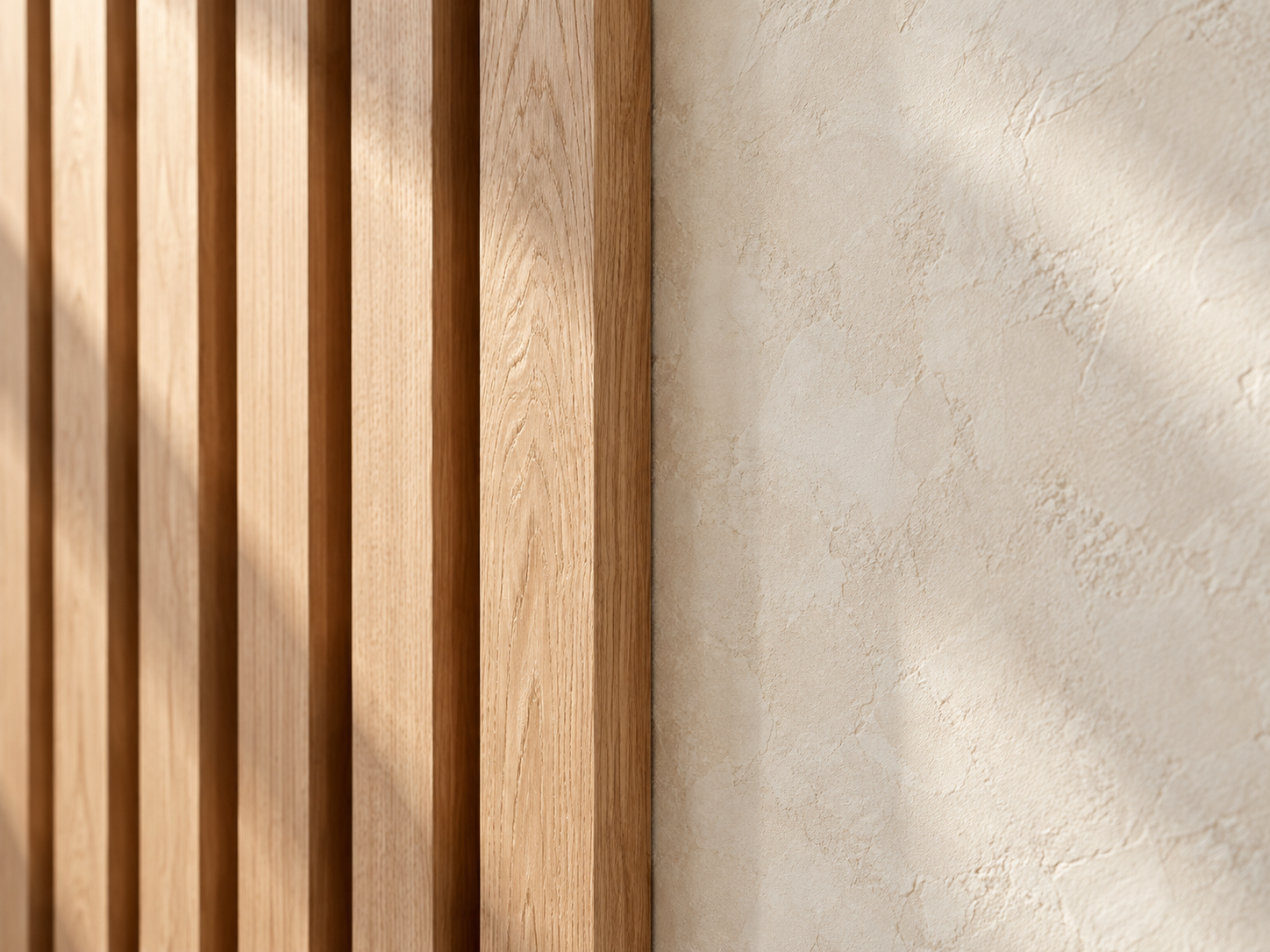 Close-up of a wooden slatted wall meeting a textured beige wall.
