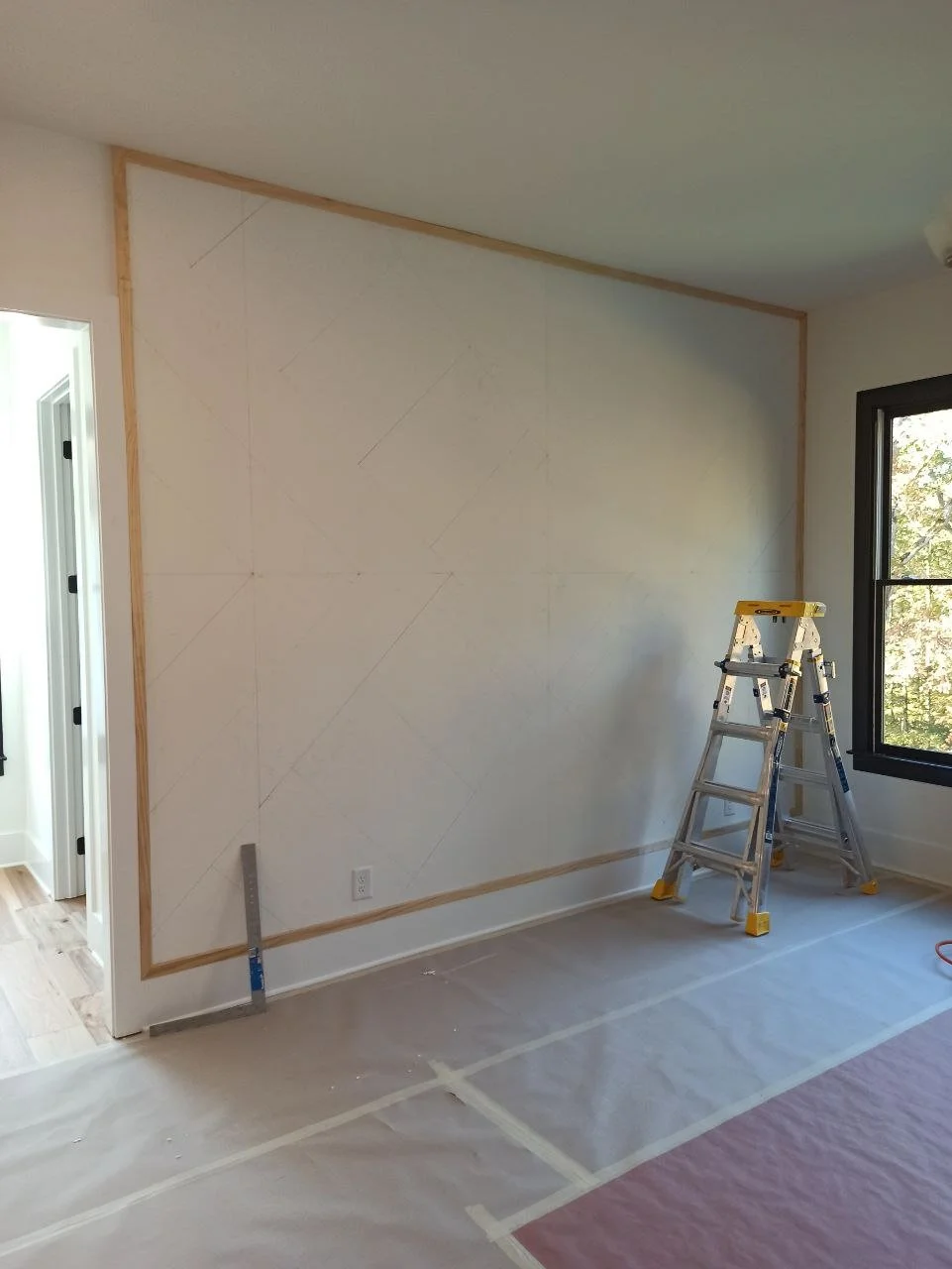 Wall layout process with pencil lines and outer frame for board and batten accent wall design in Atlanta, Georgia.