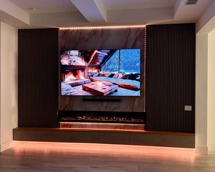 Modern Slat TV Media Wall with Fireplace and Floating Cabinetry in Englewood, Florida | Avileve.com 

This custom TV media wall project in Englewood, Florida transformed a blank living room wall into a dramatic architectural centerpiece designed arou