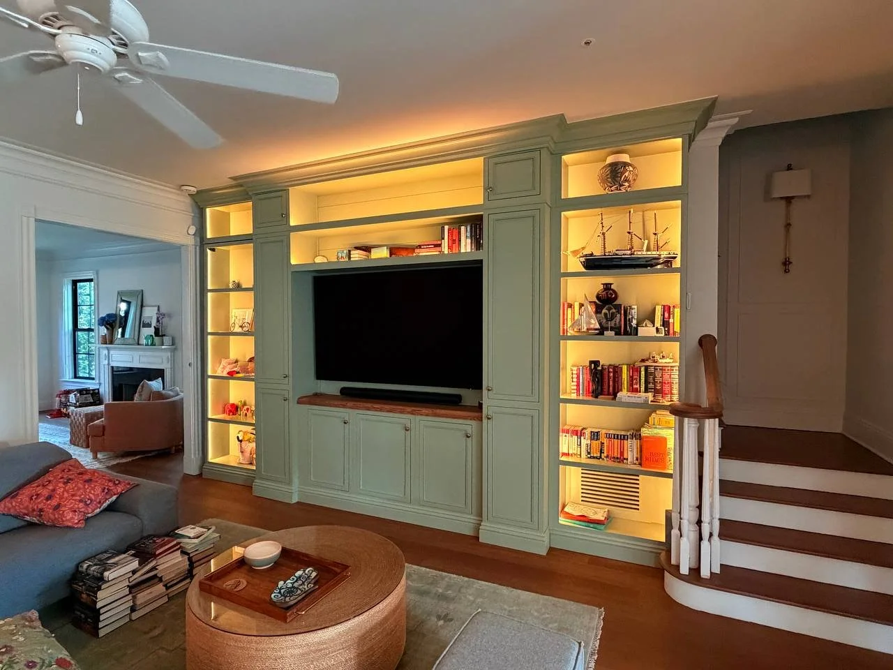 Living room entertainment center with illuminated shelving in Orlando home