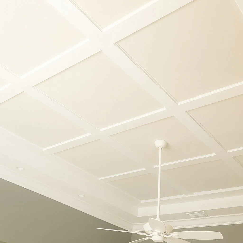 Minimalist white coffered ceiling with slim decorative beams and modern white ceiling fan.