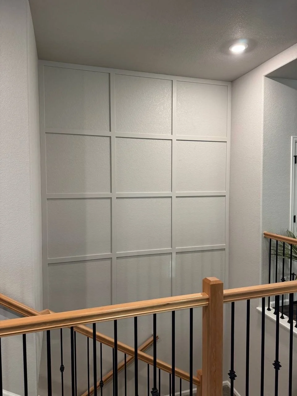 Classic grid accent wall installed in a tall stairwell in Tampa, Florida.