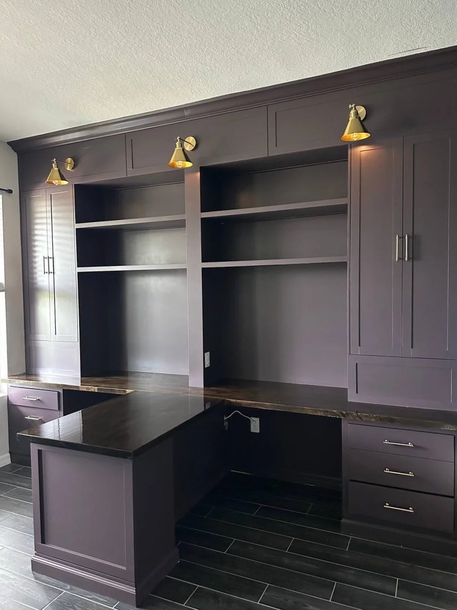 Angled view of Orlando home office built-ins with two desk areas, a central peninsula, upper cabinets, and open shelves.
