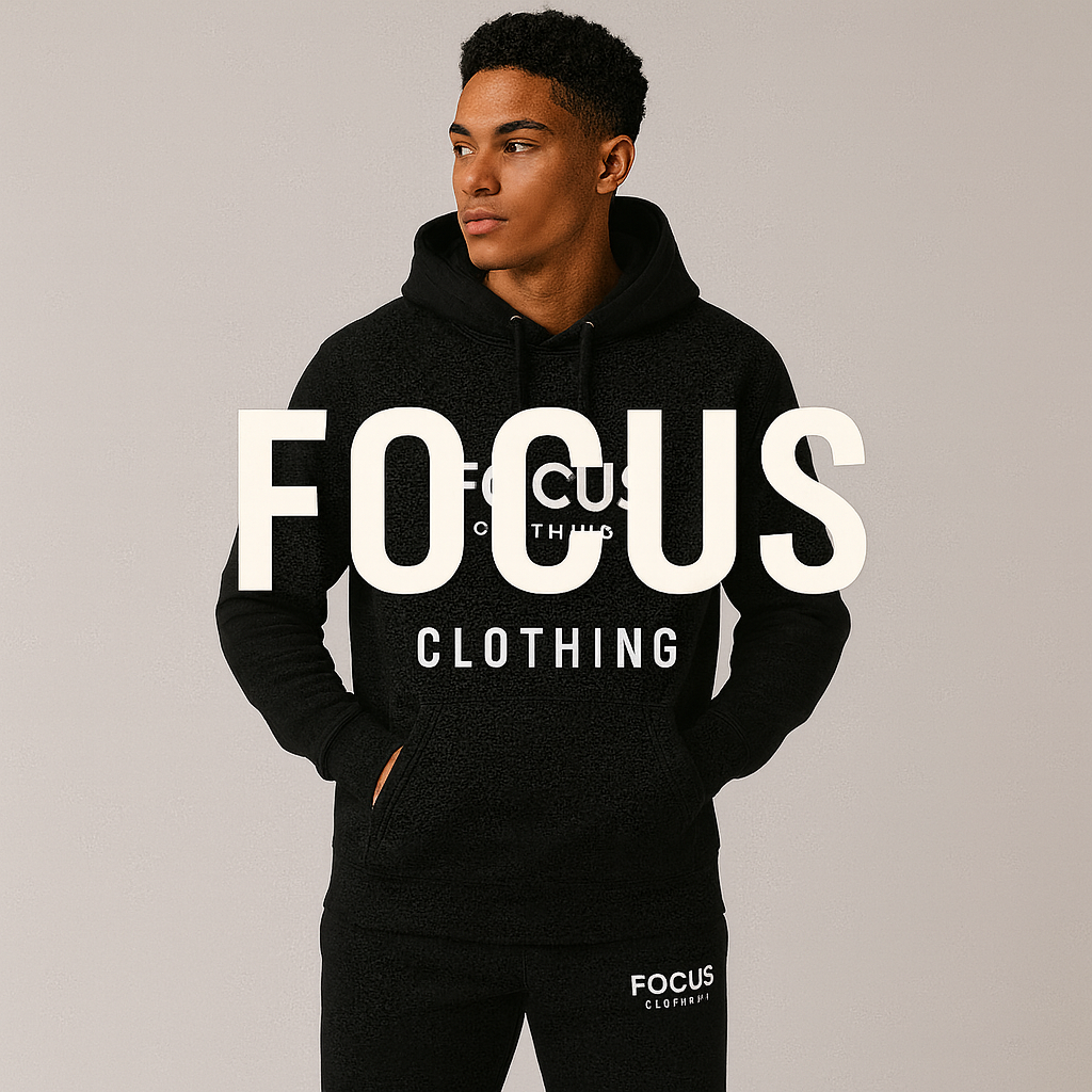 A young man wearing a black hoodie and matching sweatpants standing against a plain light gray background. The text "FOCUS" is displayed prominently across the image, and smaller text underneath reads "CLOTHING." The hoodie has a front pocket and drawstrings, with the logo "FOCUS CLOTHING" visible on the chest.
