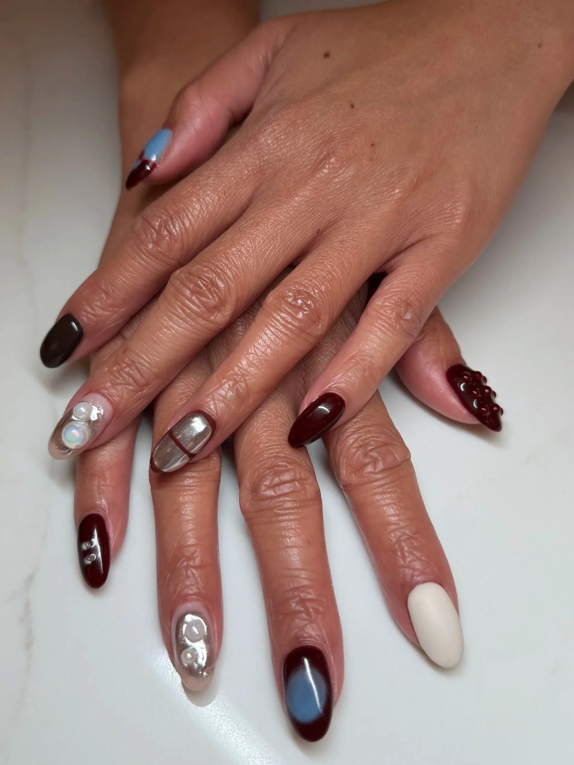 Custom set of Gel Extensions, featuring isolated chrome, beads, aura nails, and a hand-painted design