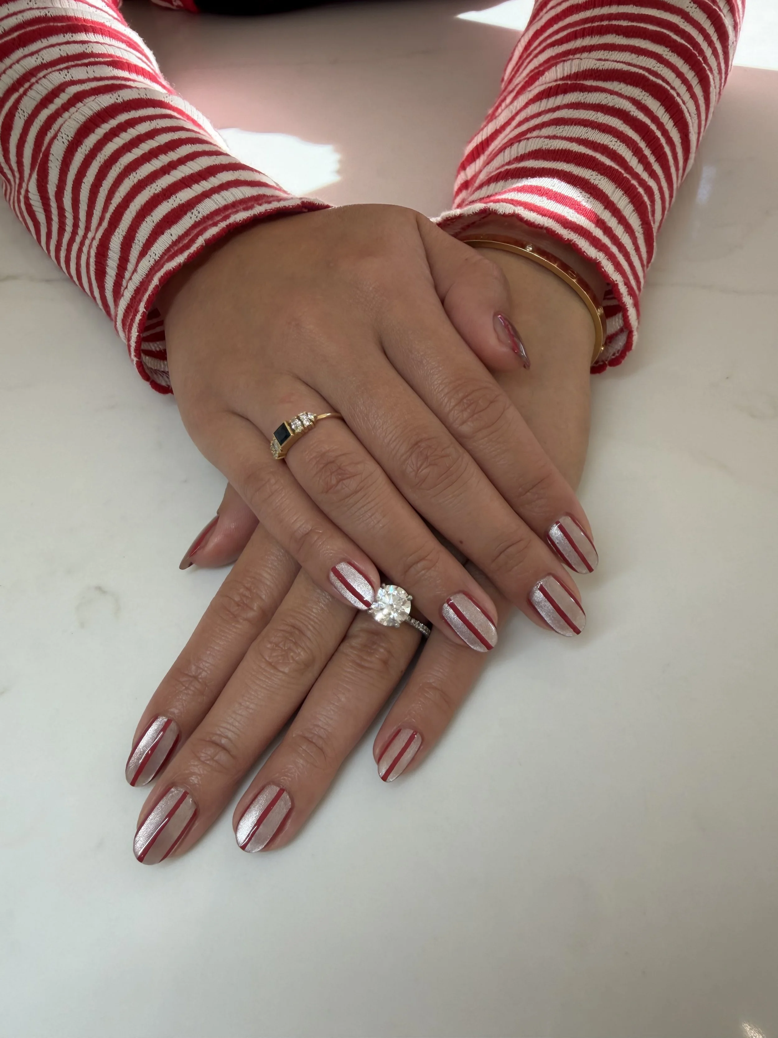 Candy cane nails with a silver cat eye base and red stripes