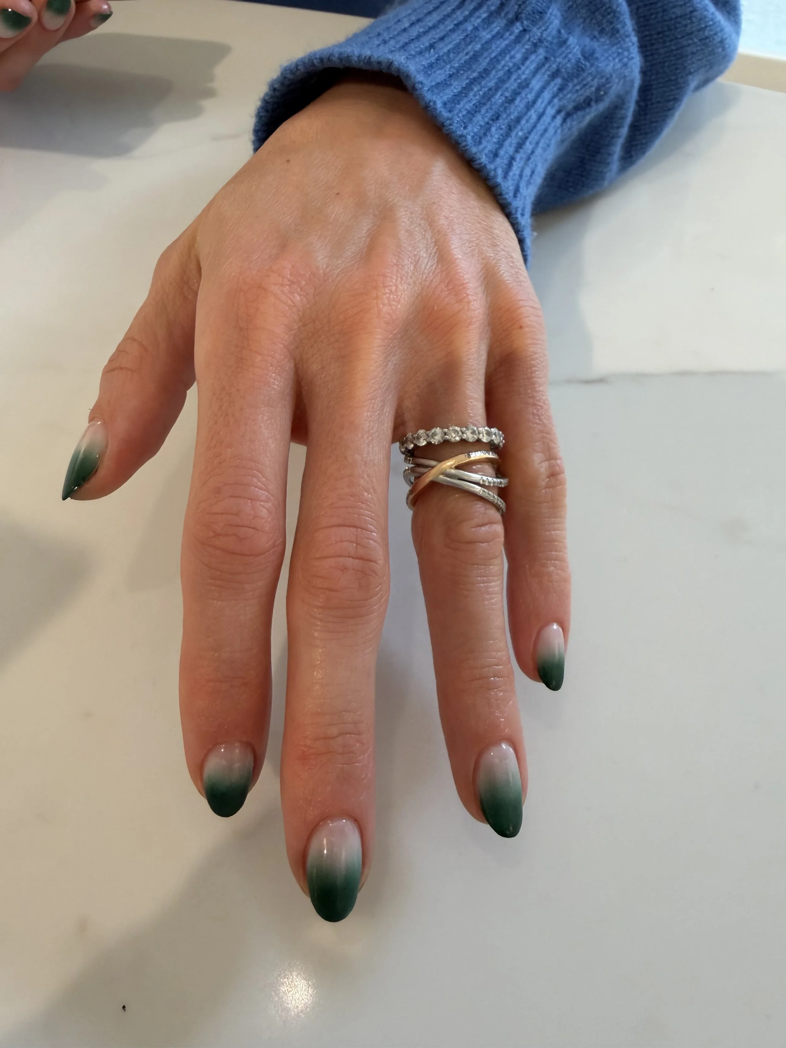 Gel manicure with a milky white base and green ombre, achieved with patting gels. 