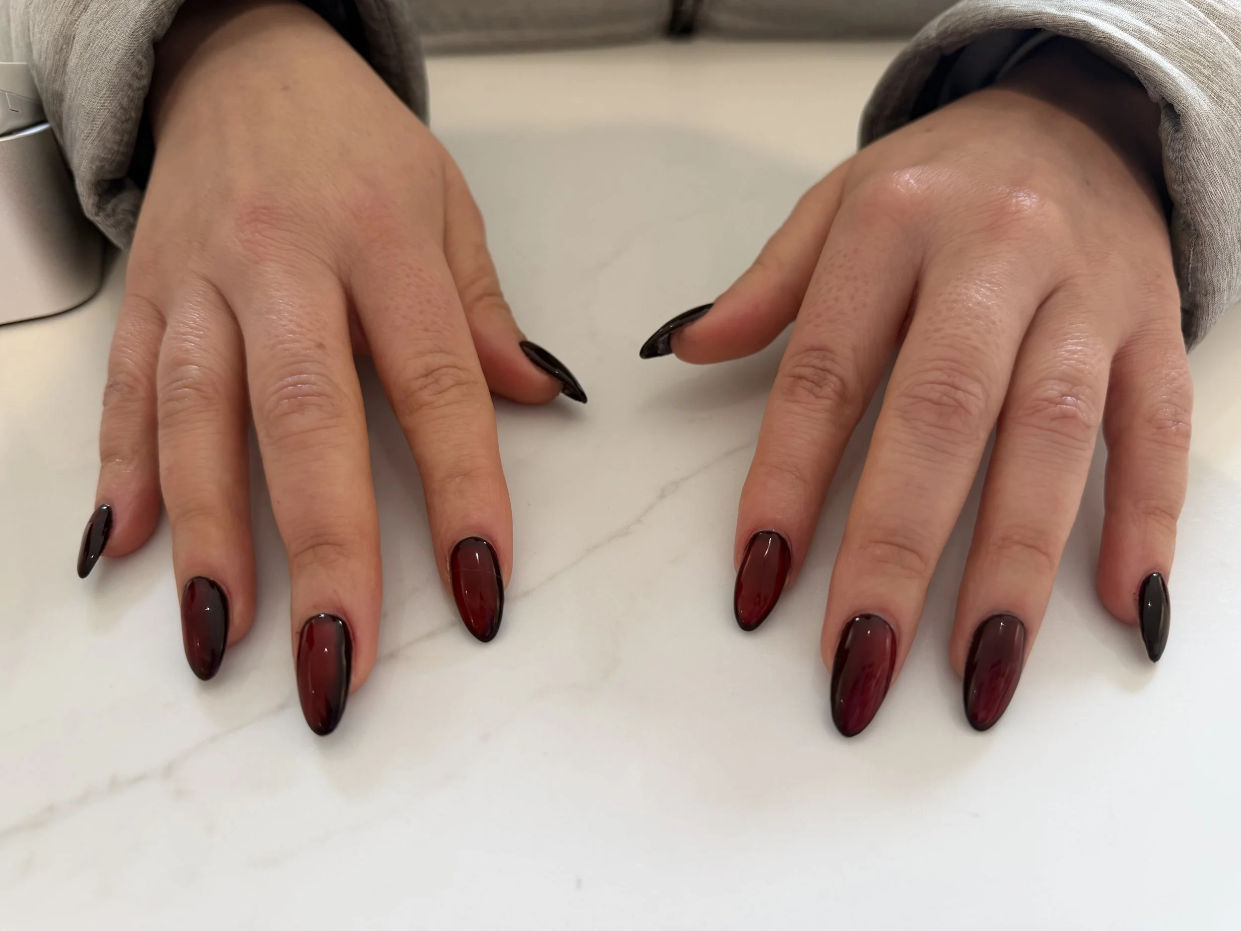Gel extensions with a black base and red cat eye