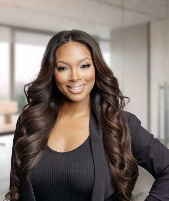 Woman in a black blazer and top smiling with an office background behind her