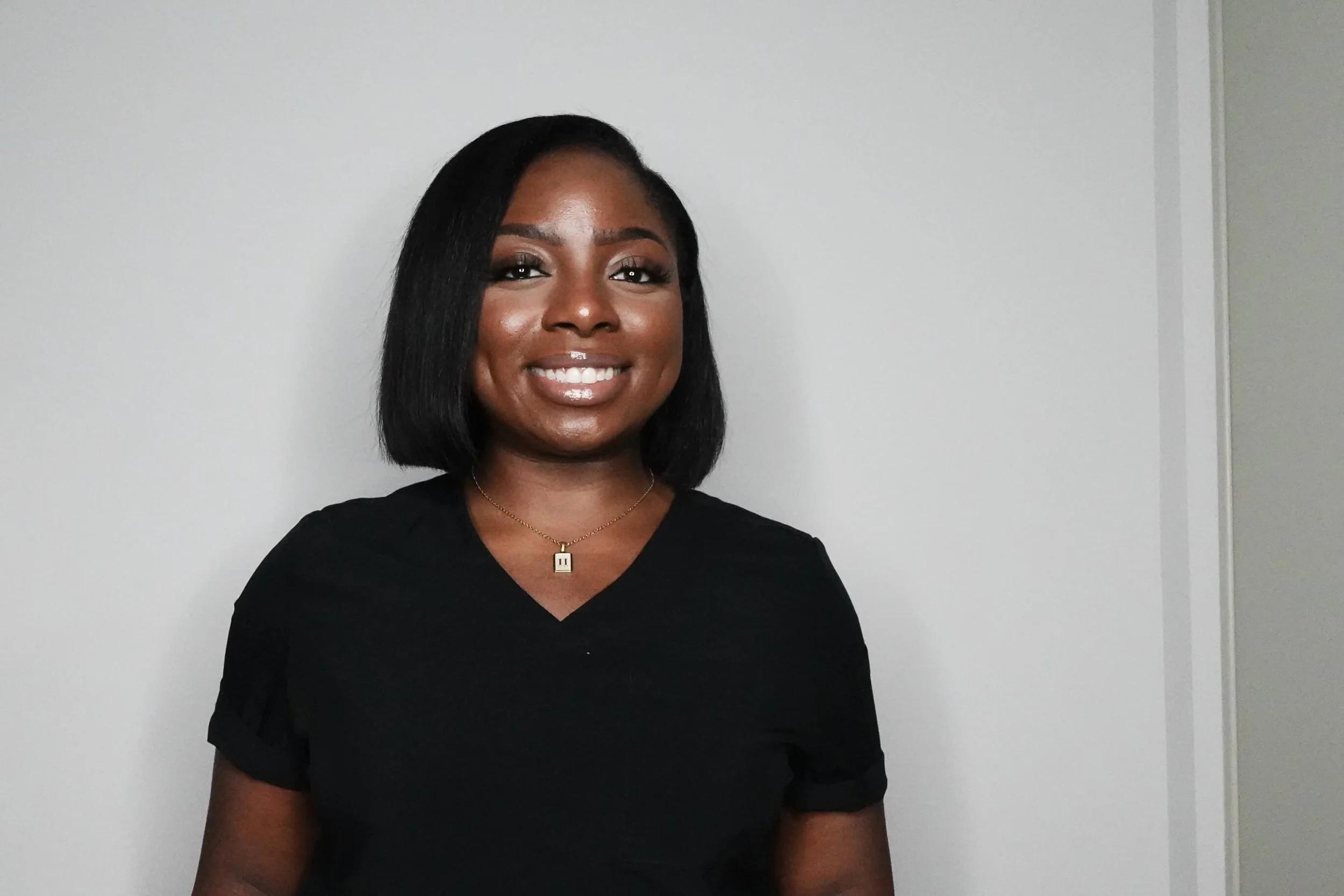 Woman wearing a black shirt against a neutral wall