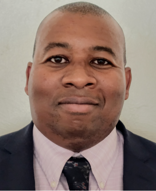 Close-up of a smiling African American man in a suit and tie.