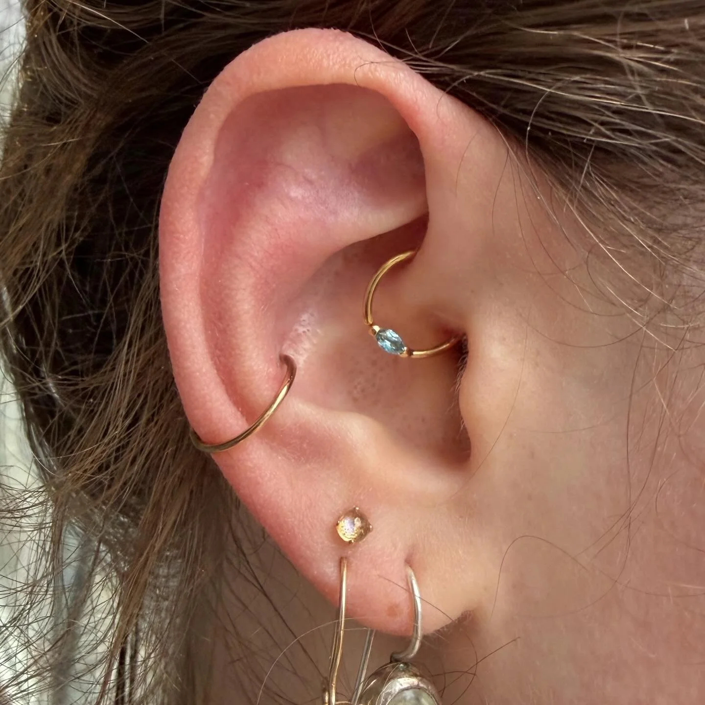 An absolutely gorgeous new daith piercing featuring Swiss Blue Topaz in yellow gold!