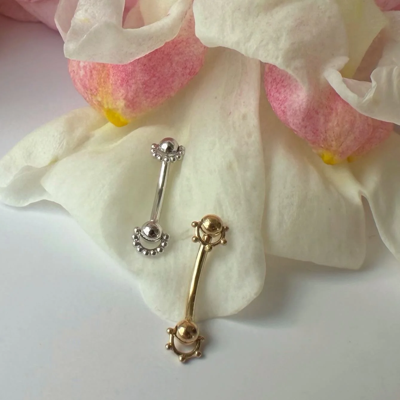 We have a couple of these super unique curved barbells available in white and yellow gold from Pupil Hall! They would look amazing in any rook piercing, or could work in a healed eyebrow!