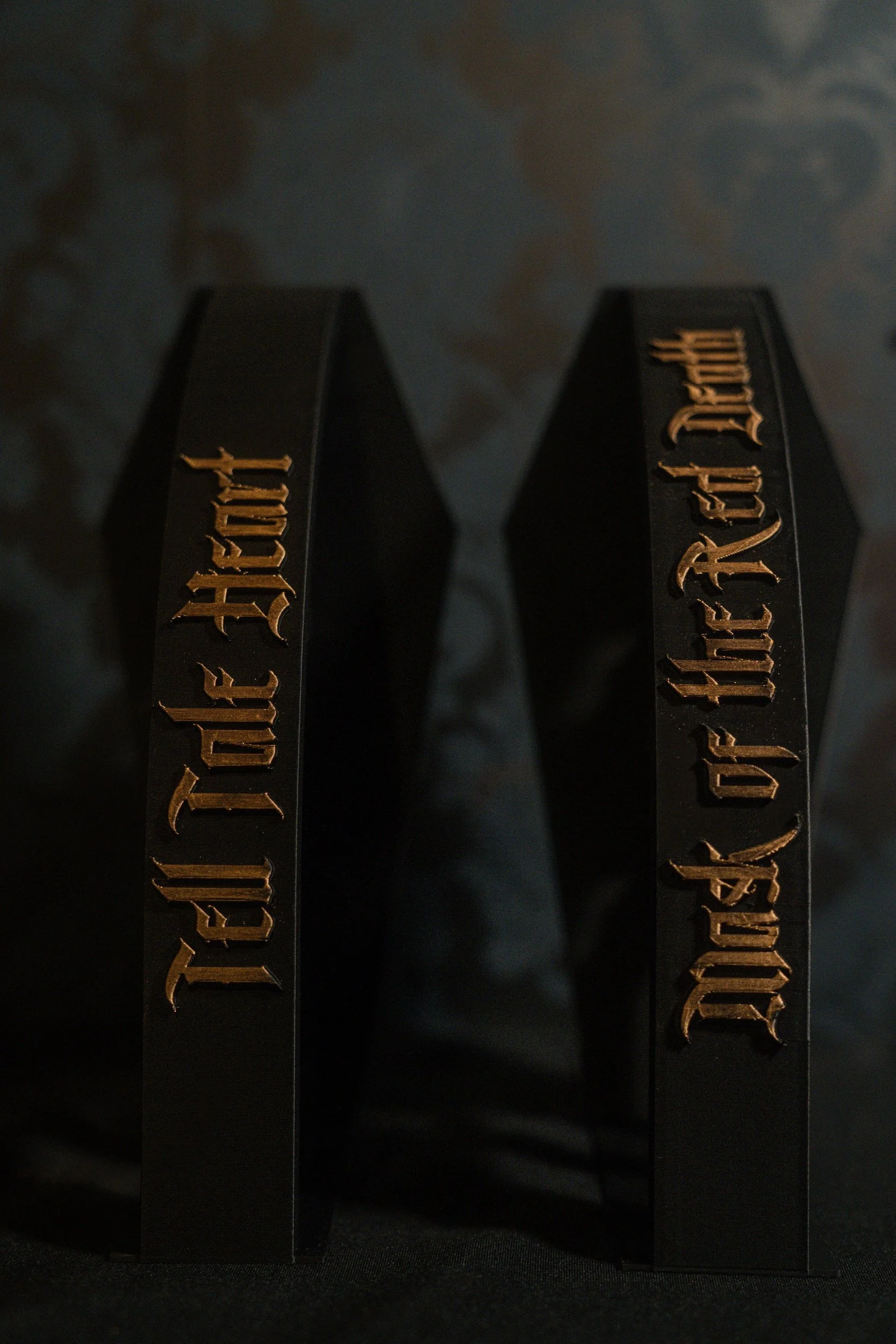 Two black rectangular objects with gold gothic text reading 'Mask of the Red Death' and 'Tale-Tell Heart'.