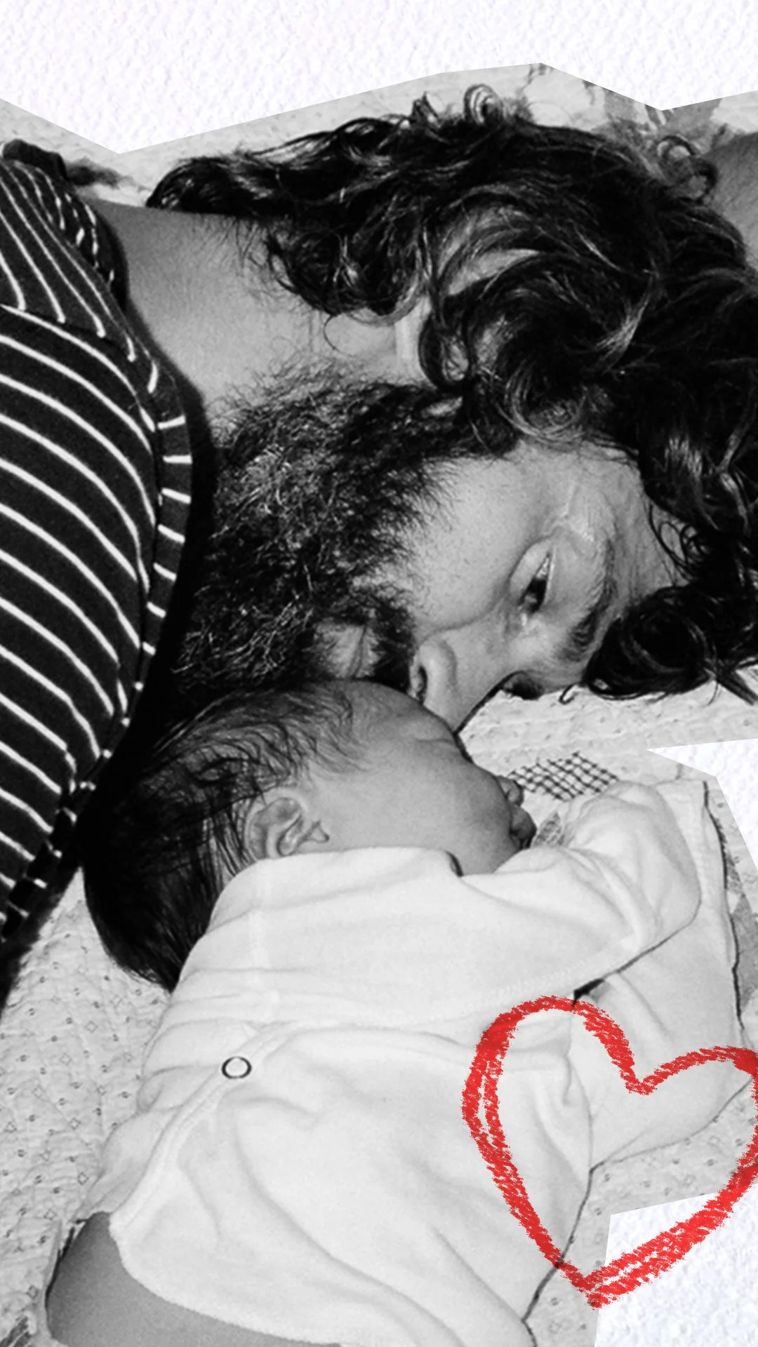 A black and white photo of a father with curly hair and a beard lying down with his newborn baby, who is sleeping, touching noses. A red heart is drawn on the bottom right corner of the image.