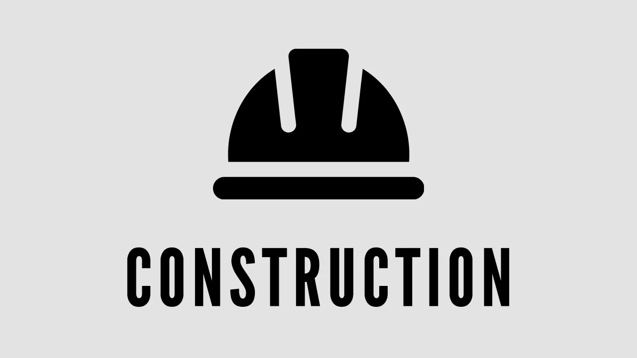 Icon of a construction helmet above the word 'CONSTRUCTION' in black on a light gray background.