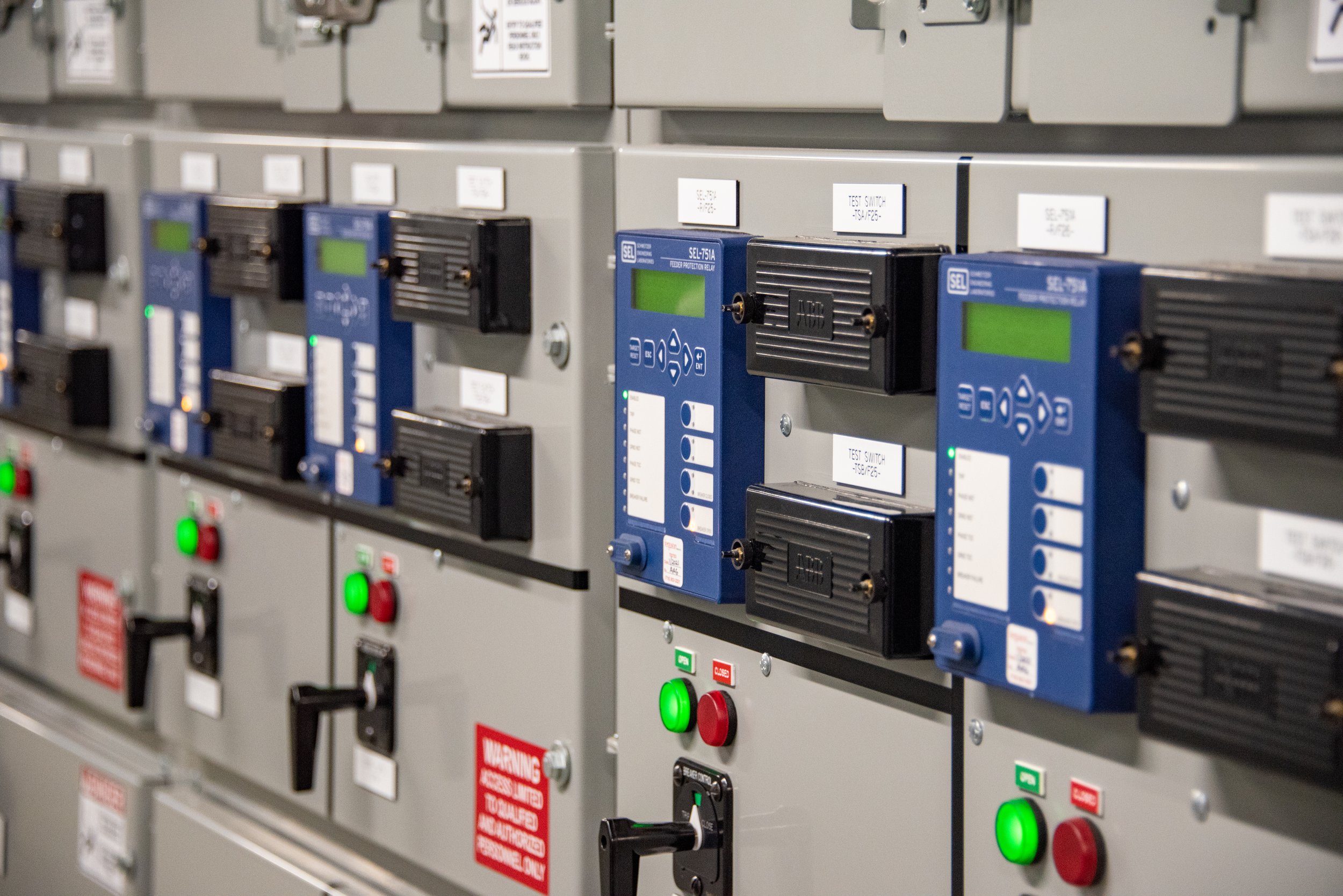 Close-up of an electrical control panel with multiple circuit breakers, switches, and indicator lights.