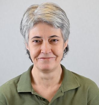 Portræt af en kvindelig person med kort, gråt hår iført en grøn polo shirt mod en lys baggrund.