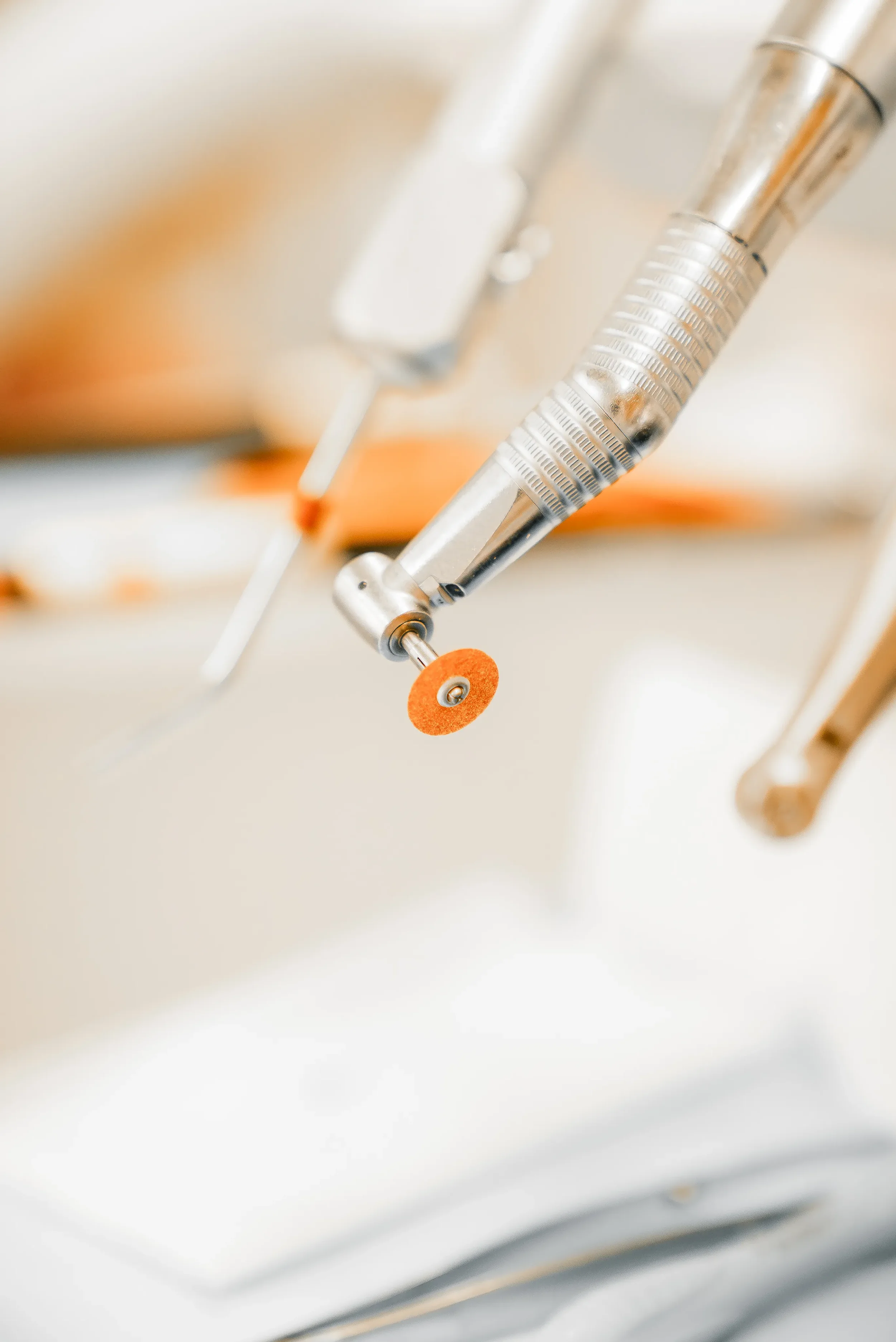 Nærbillede af medicinsk udstyr med metal og orange plastdele.