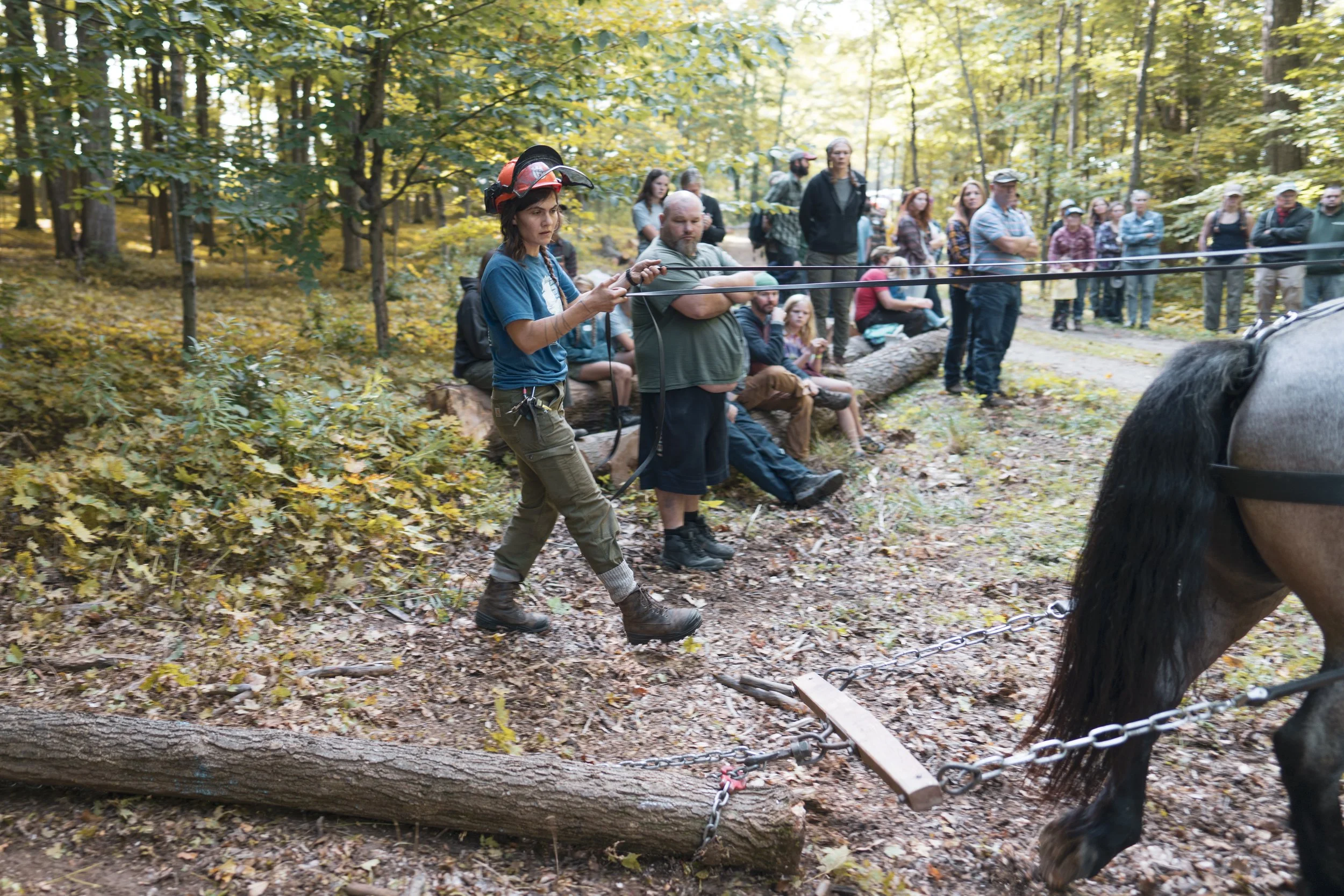 Young woman logger teaches workshop at Draft Animal Power Field Days 2023.