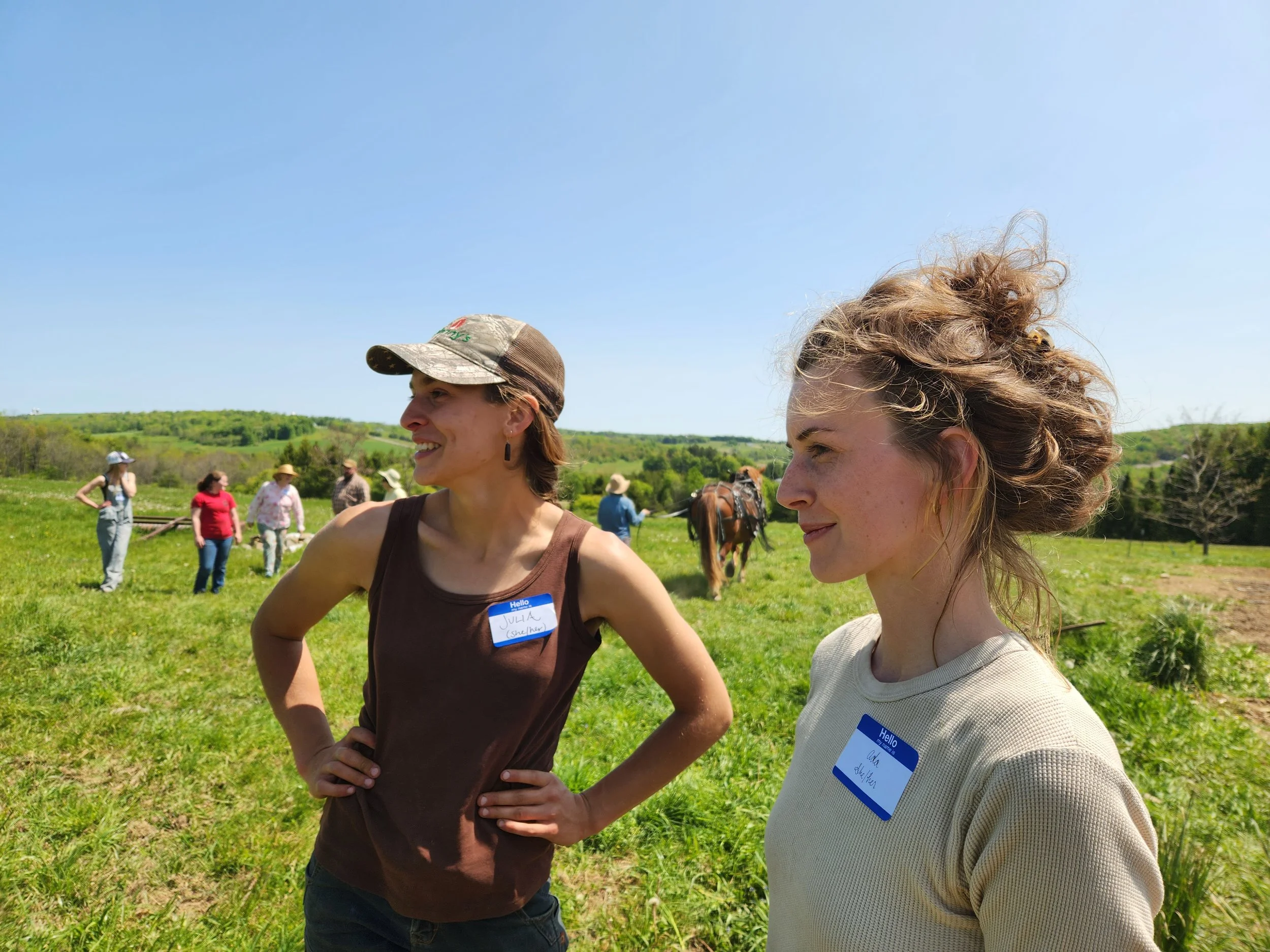 Two young woman farmers at Draft Animal Power Network's LGBTQ Field Day gathering.