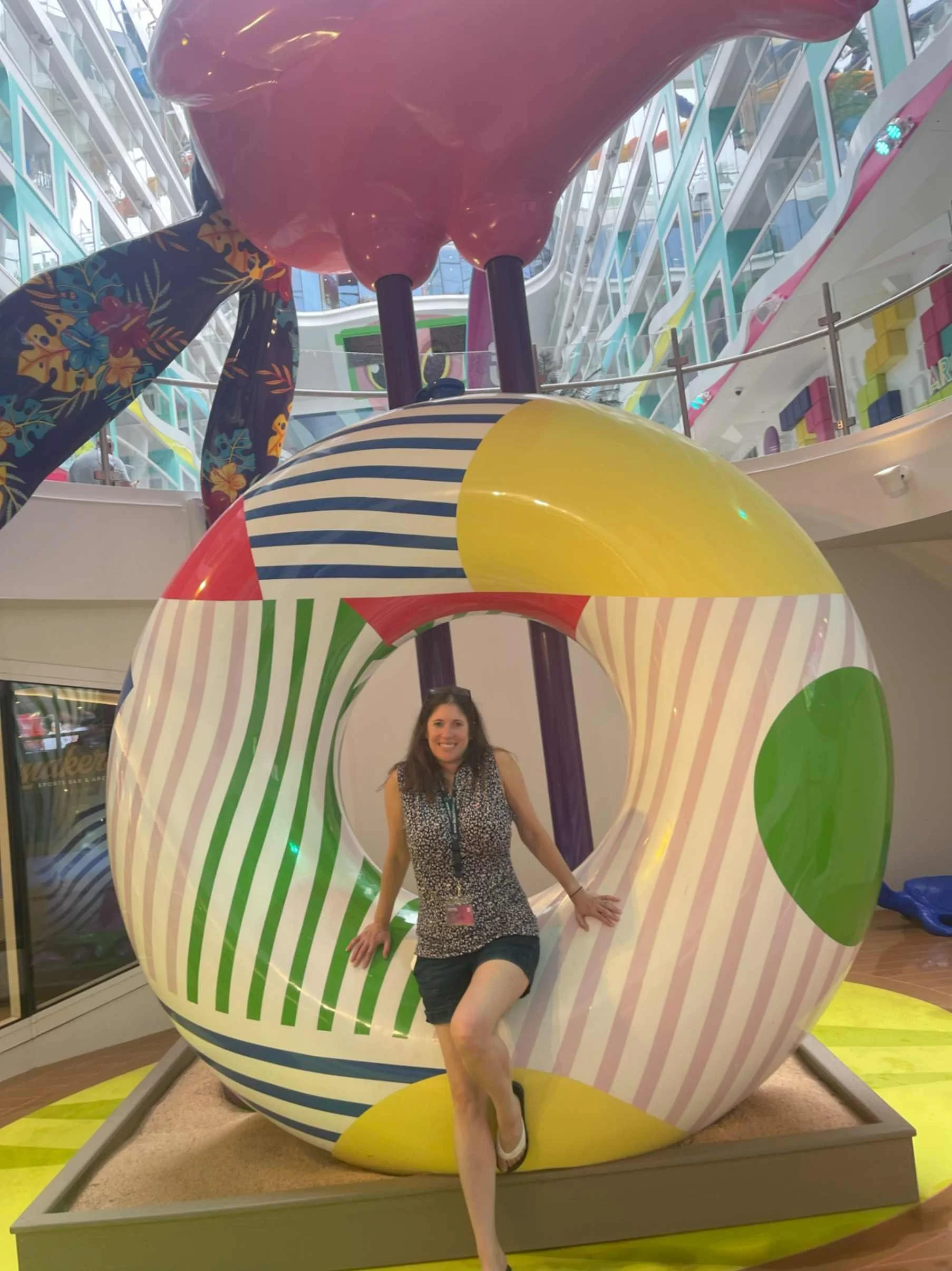 Colorful scene in the Surfside Neighborhood aboard Royal Caribbean’s Icon of the Seas featuring a large pink flamingo statue, carousel, and family play area. A bright, cheerful space designed for family cruising.