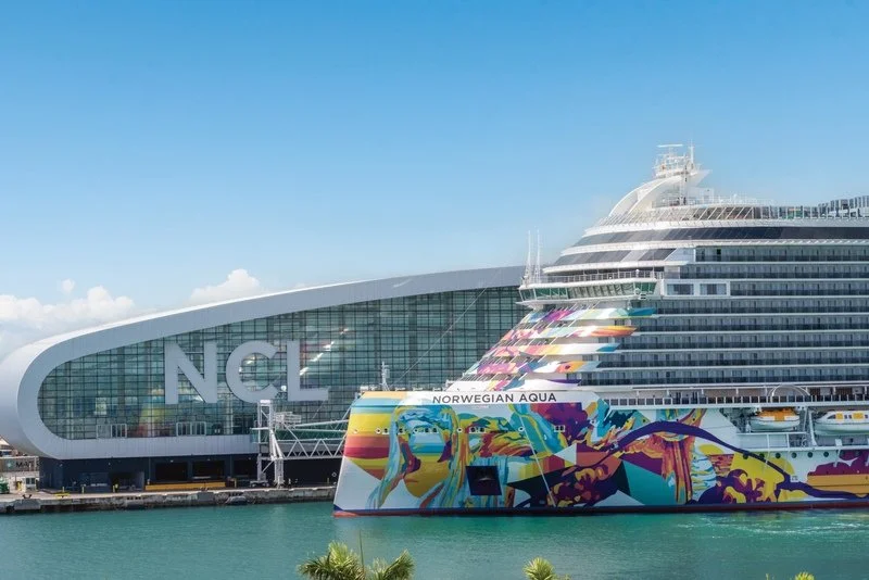 Norwegian Aqua cruise ship docked at the Norwegian Cruise Line terminal in the Port of Miami under a clear blue sky