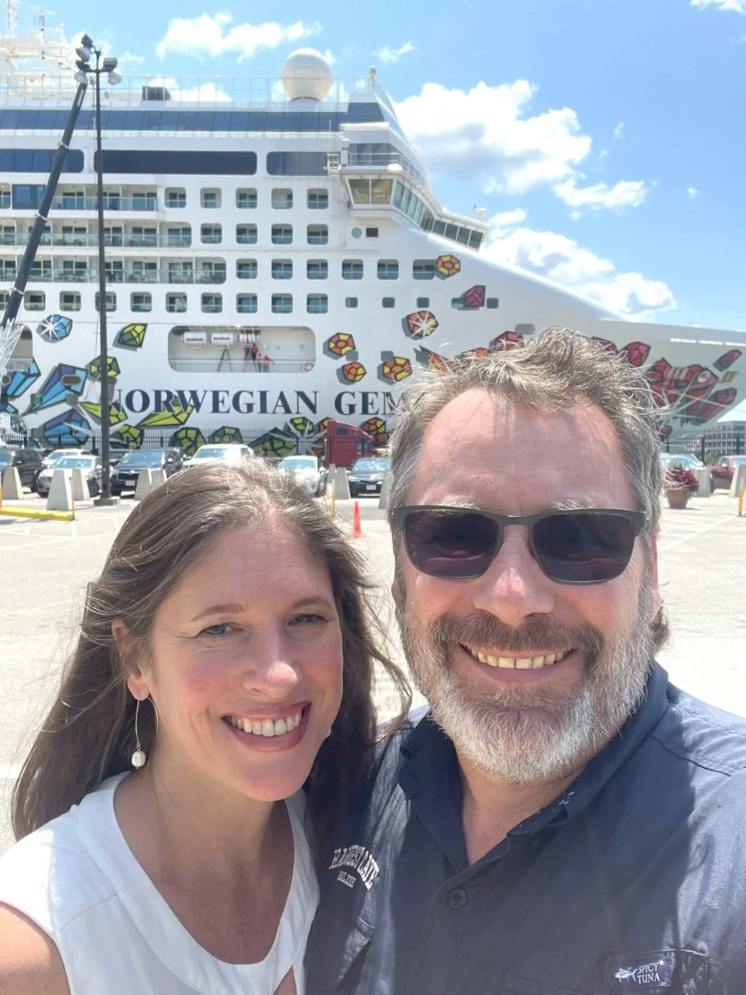 Go Joe Travel founder Joe and his wife Ali smiling in front of the Norwegian Gem cruise ship during a familiarization trip.
