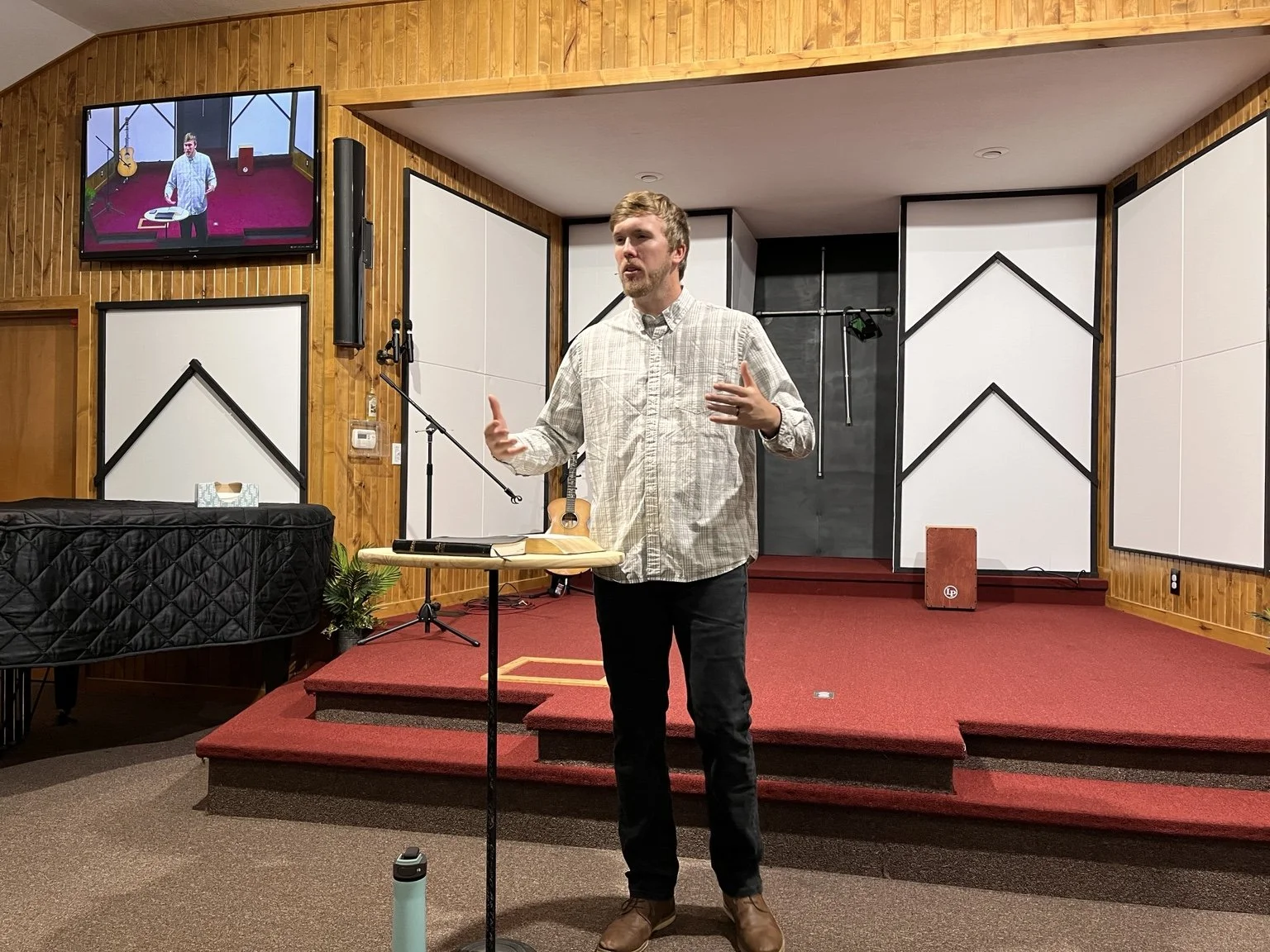 Jeremy Groves teaching with an open Bible at a church gathering.