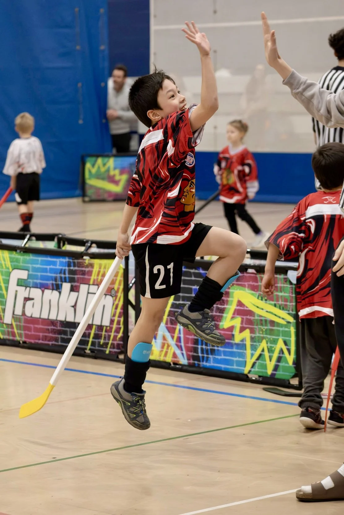 Young athlete high fives teen ref during an indoor Sunday Funday Sports game near Willowbrook IL