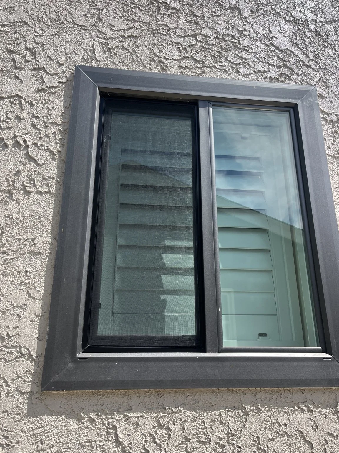 Custom black window screen installed by The Screen Machine