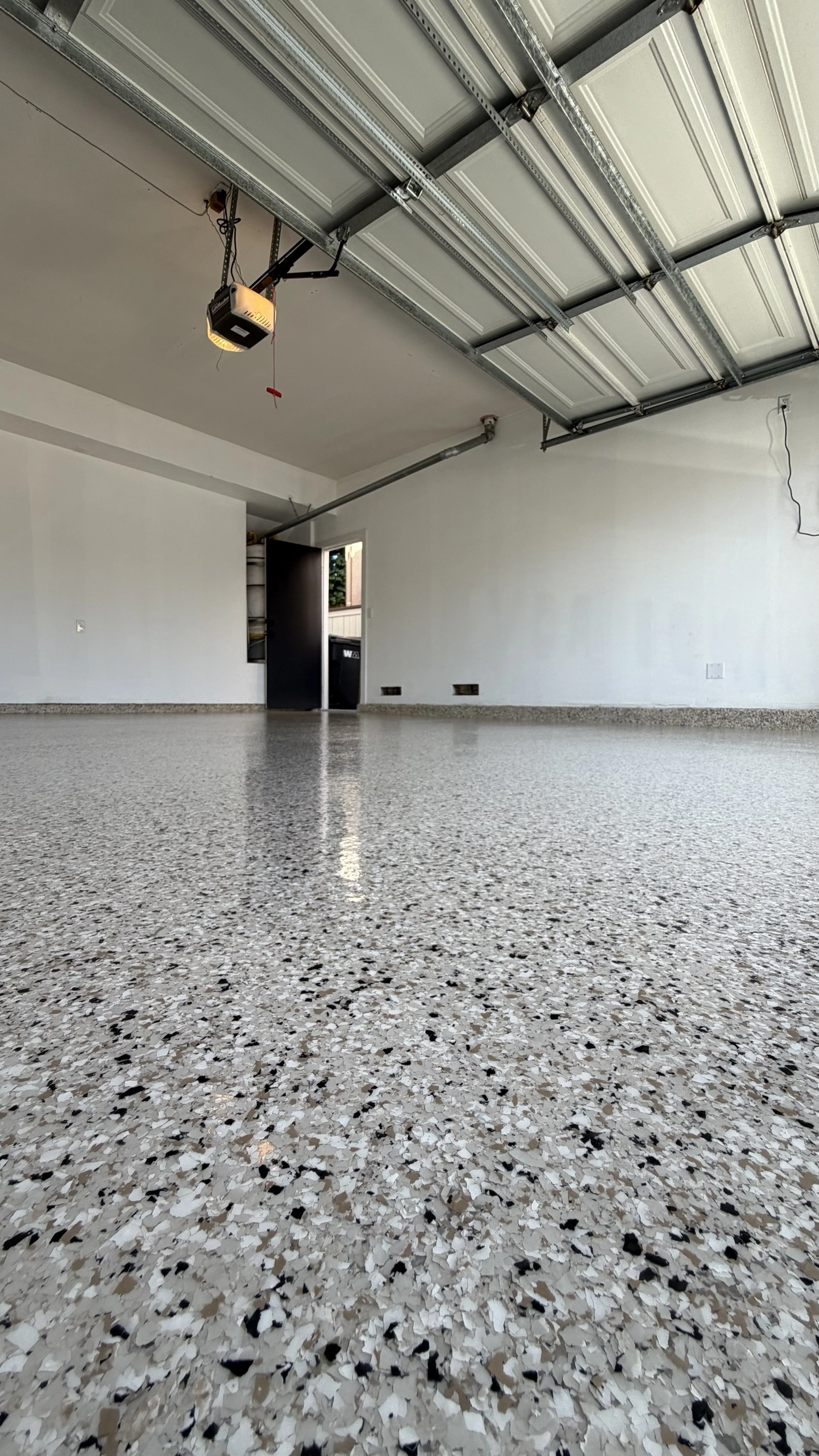 Two-car garage with gray decorative flake epoxy floor and clear topcoat in Laguna Beach, CA