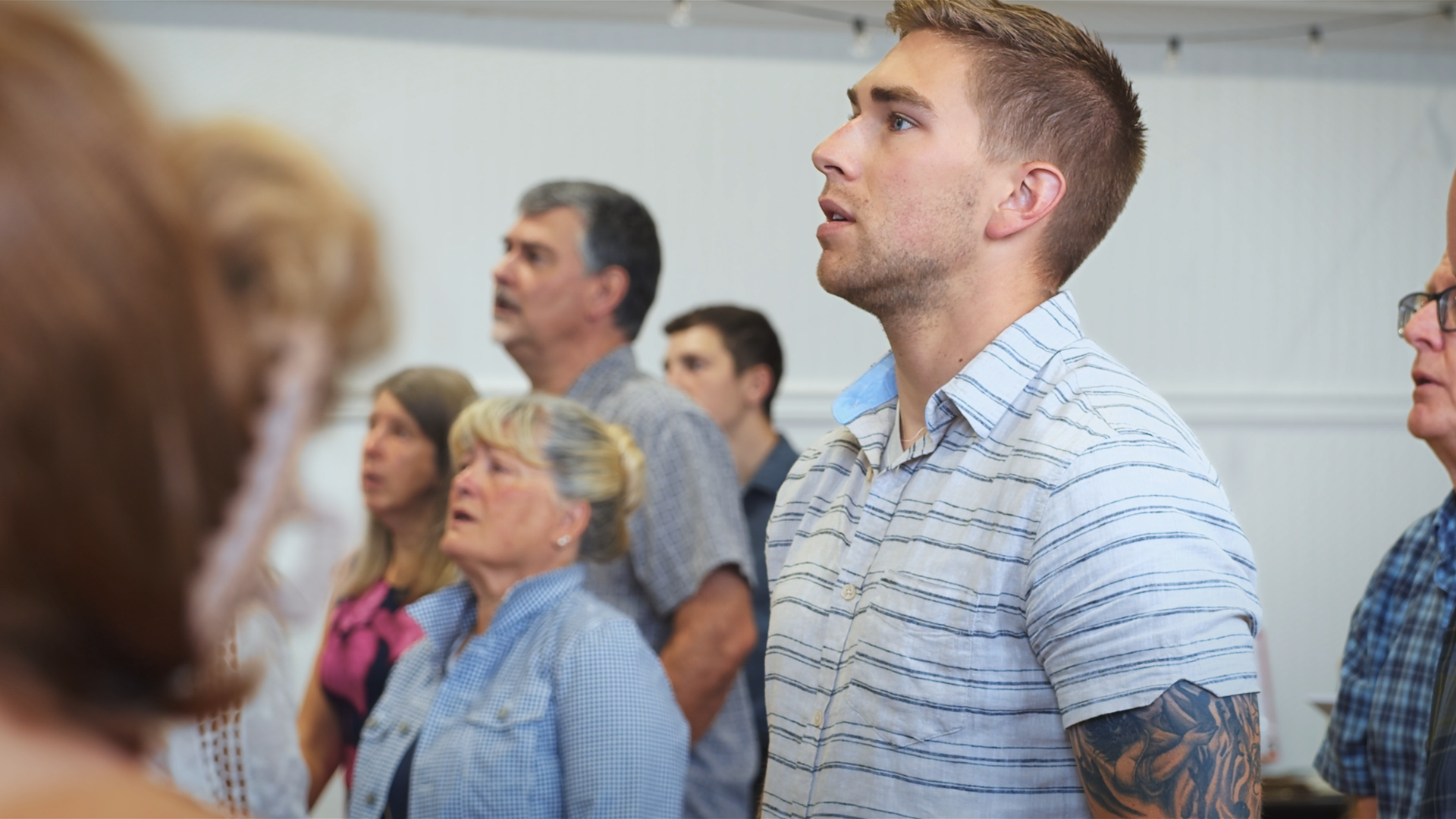 Group of people standing together in a worship service.
