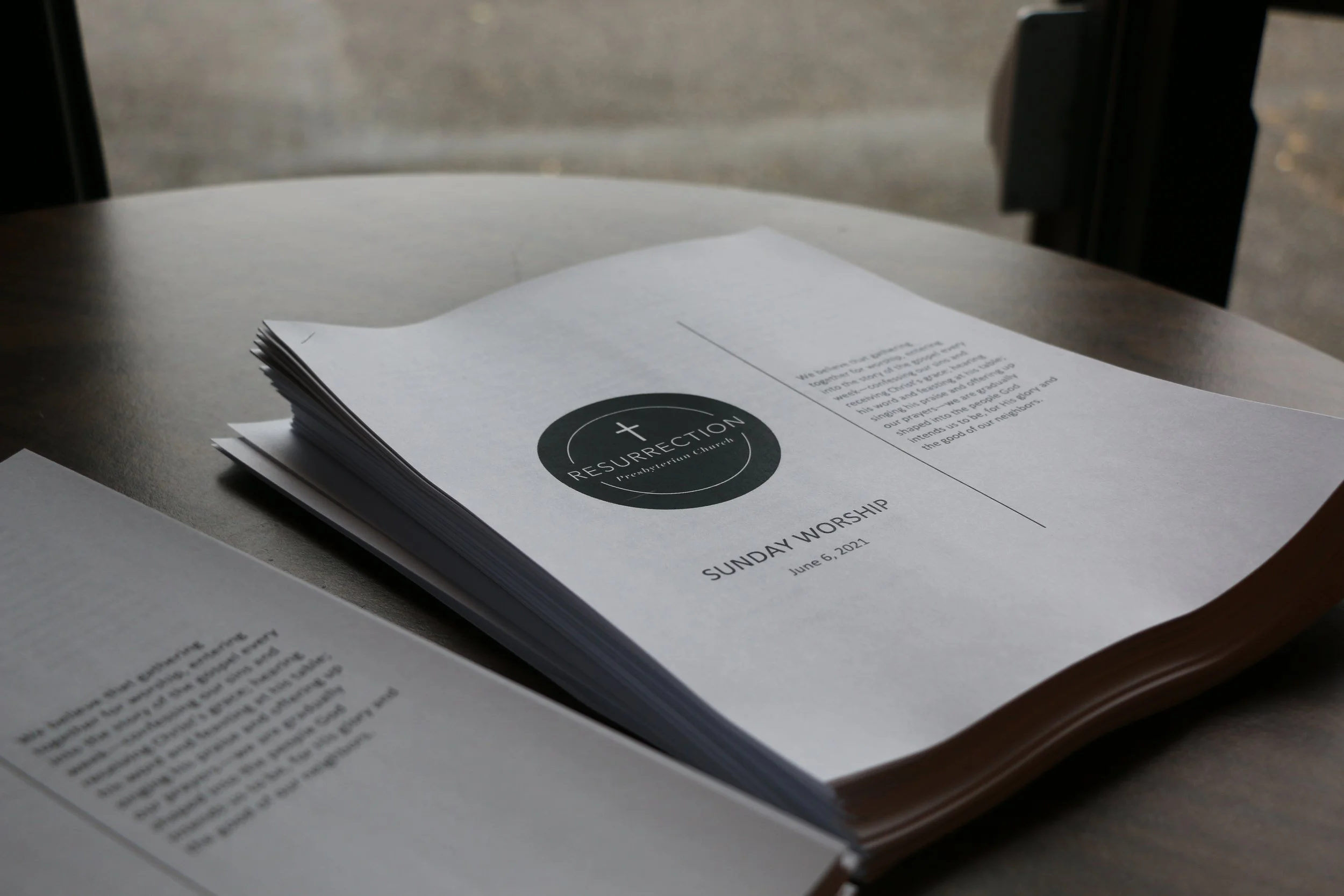 A weekly worship program pamphlet for Resurrection Fellowship Church, dated June 6, 2021, resting on a table.