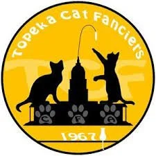 Logo for Topeka Cat Fanciers, 1967, featuring black silhouettes of two cats, one sitting and one standing, with a city skyline, a streetlamp, and paw prints in a circular yellow background.