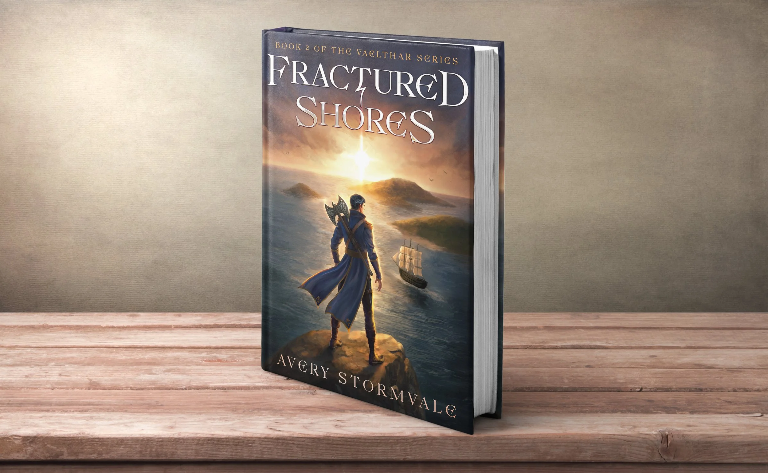 A hardcover book titled 'Fractured Shores' by Avery Stormvale standing upright on a wooden surface against a beige wall. The book cover features an illustrated scene of a person with a sword on a rocky outcrop overlooking a body of water, with a ship sailing nearby and a sunset or sunrise in the background.