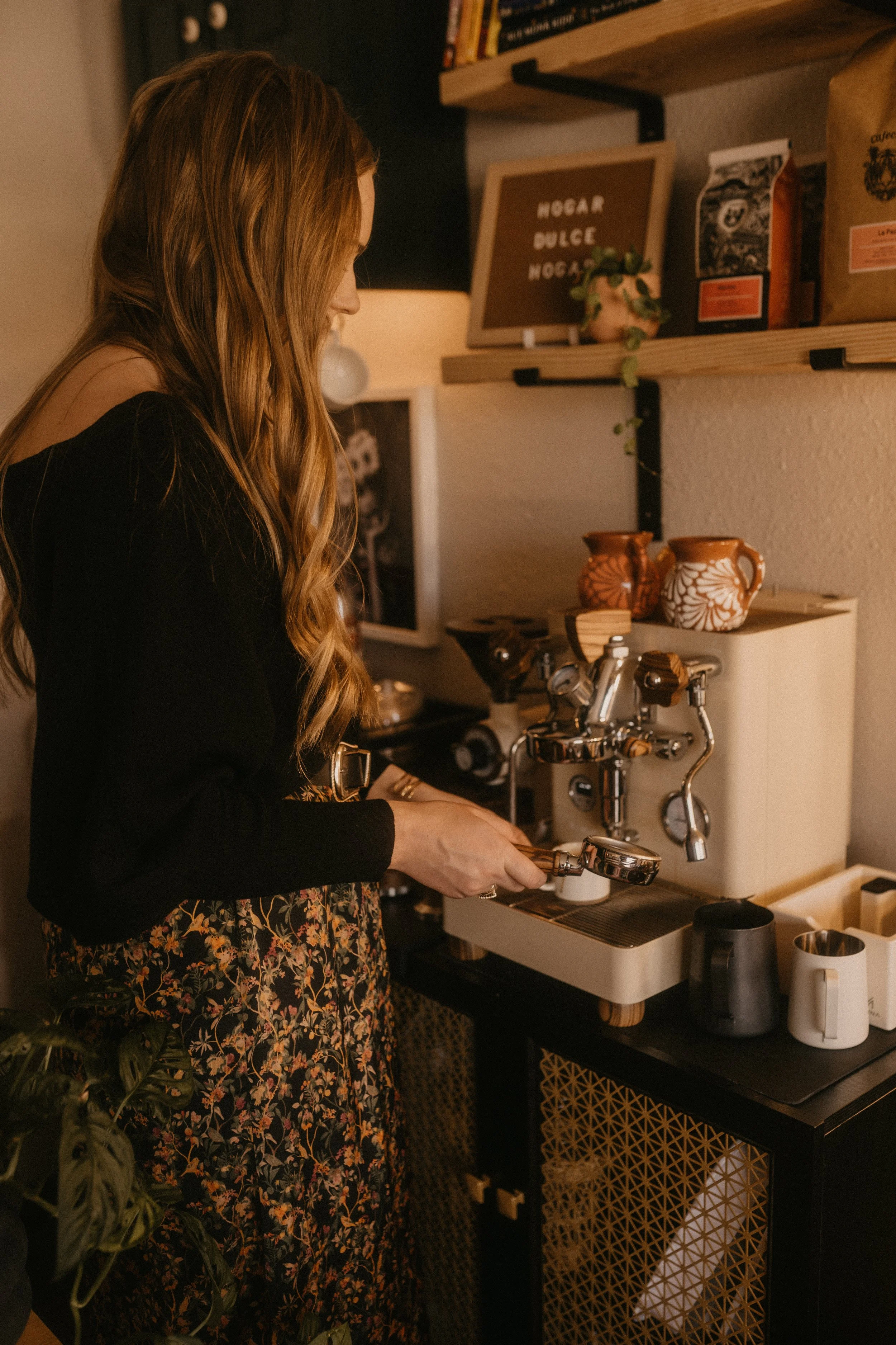 madeline pouring or pulling an espresso shot in Casa Hogar office