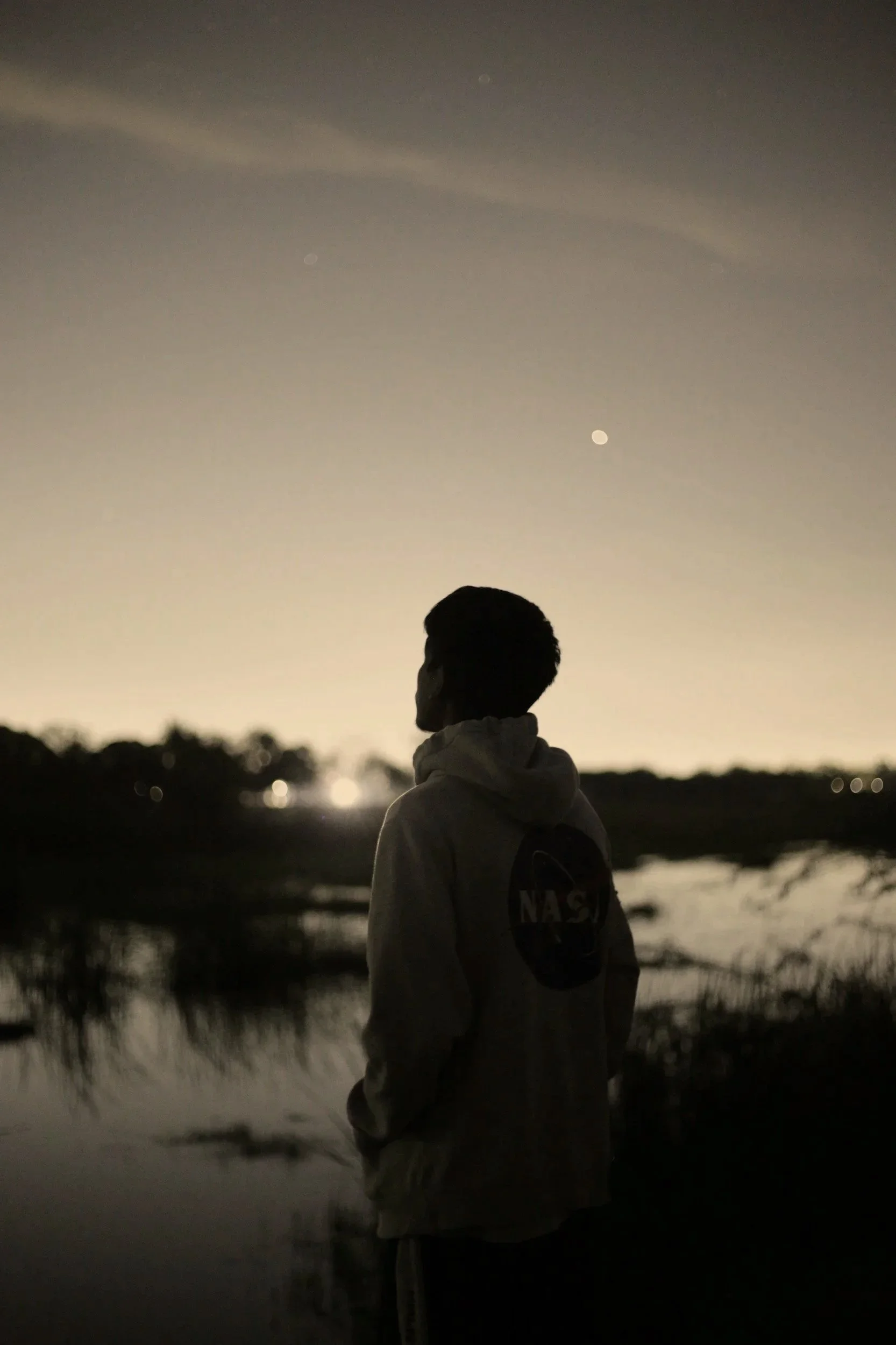 Black and white photo of immigrant staring at border